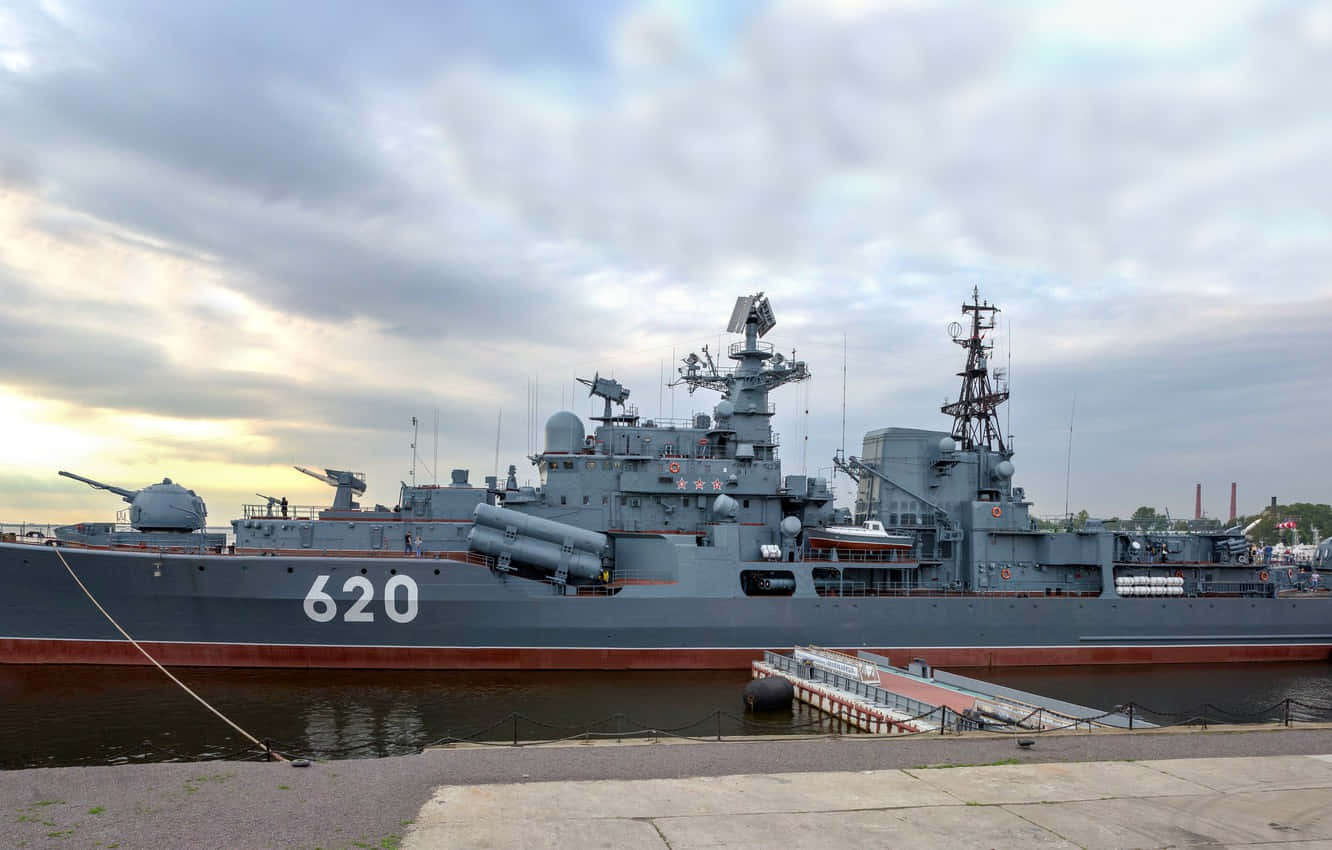 Restless 桌布 壁紙 — 一艘大型灰色海軍戰艦，編號620，停泊在碼頭，天空多雲。