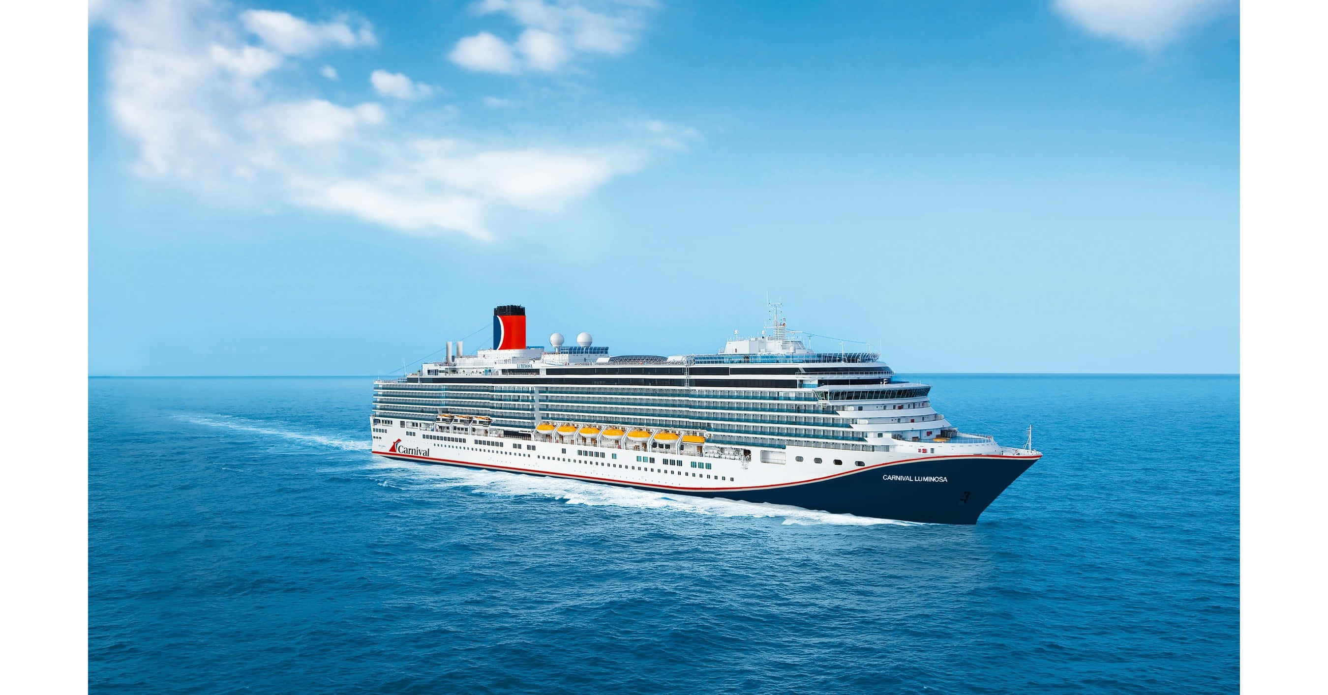 Carnival Dream 桌布 壁紙 — 一艘大型郵輪在晴朗的天空和零星雲朵下，平穩地航行在深藍色的海洋上。