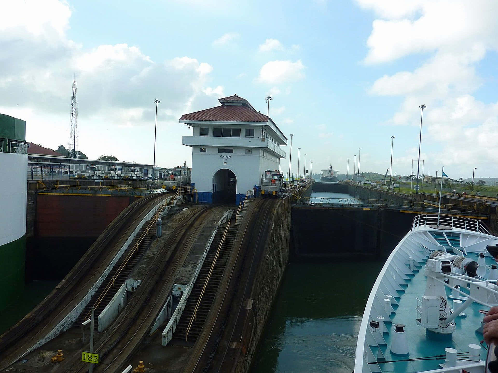 Panama 桌布 壁紙 — 一艘大型郵輪在部分多雲的天空下航行穿過巴拿馬運河的船閘系統。