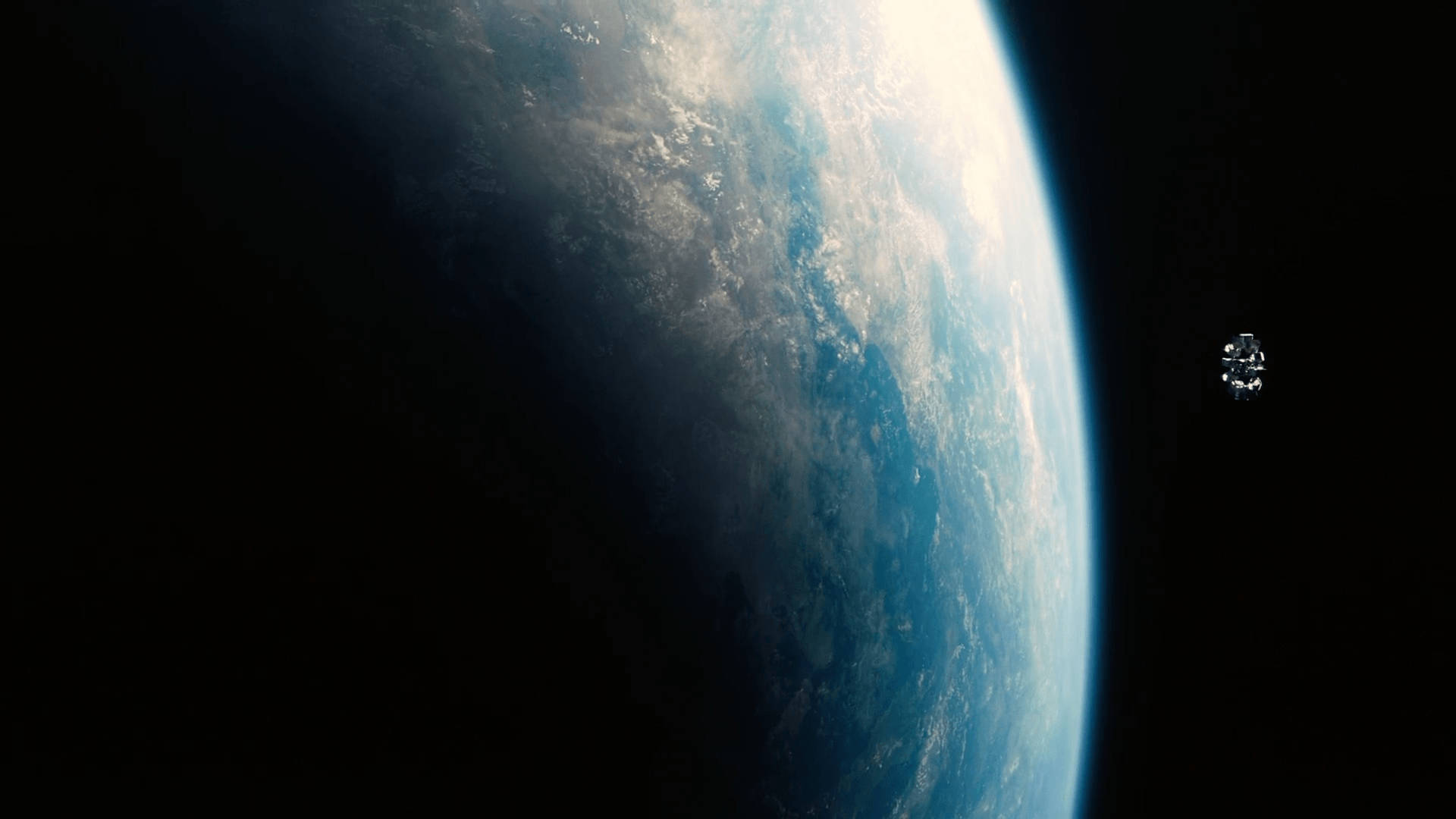 星際效應 桌布 壁紙 — 一艘太空船在彎曲的藍白地球附近漂流，背景是黑色的太空虛空。
