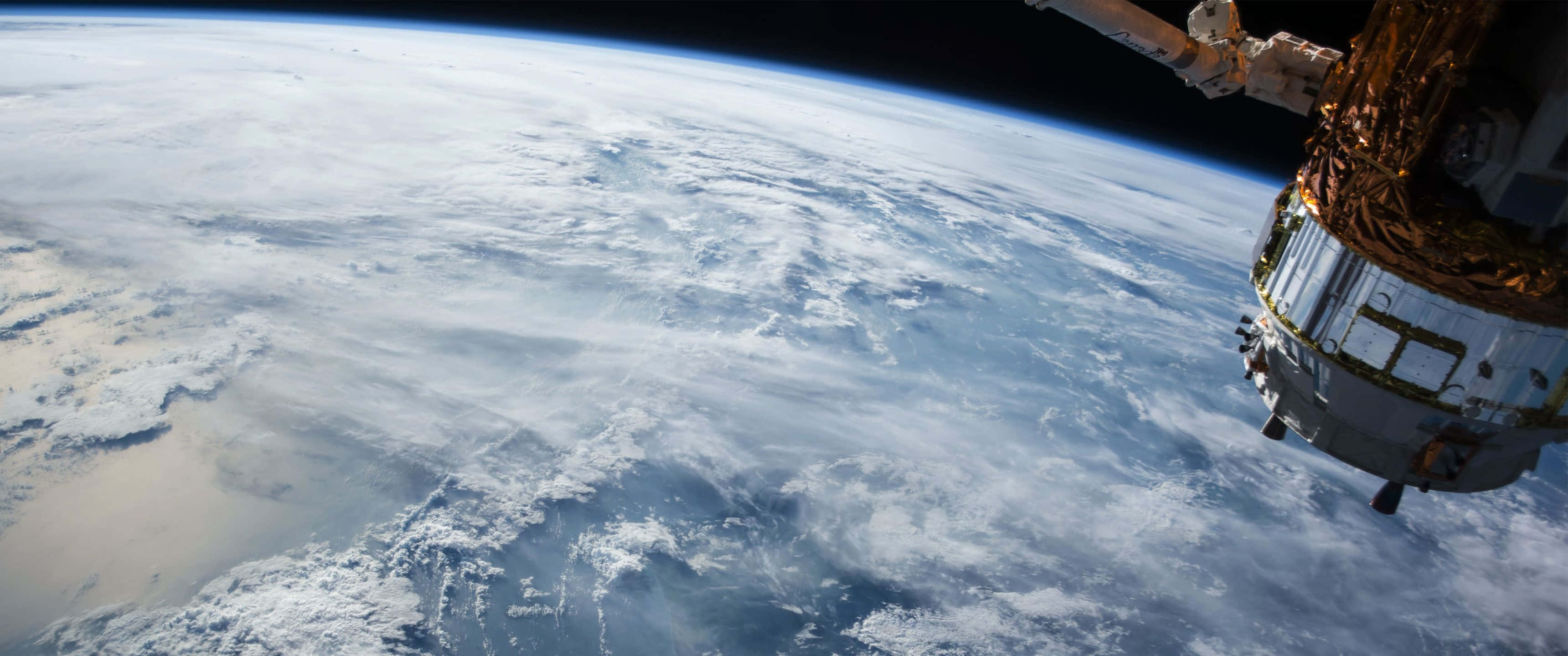 外太空 桌布 壁紙 — 一艘太空船從太空懸浮在地球旋轉的白色雲層和藍色海洋之上。
