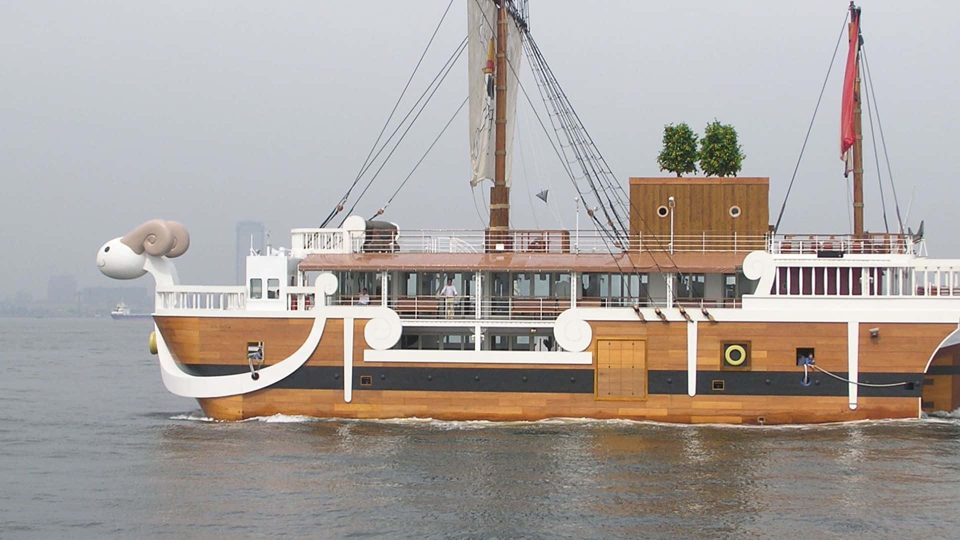 Going Merry 桌布 壁紙 — 一艘奇特的木船，船頭是公羊頭造型，在陰天灰濛濛的水面上平靜航行。