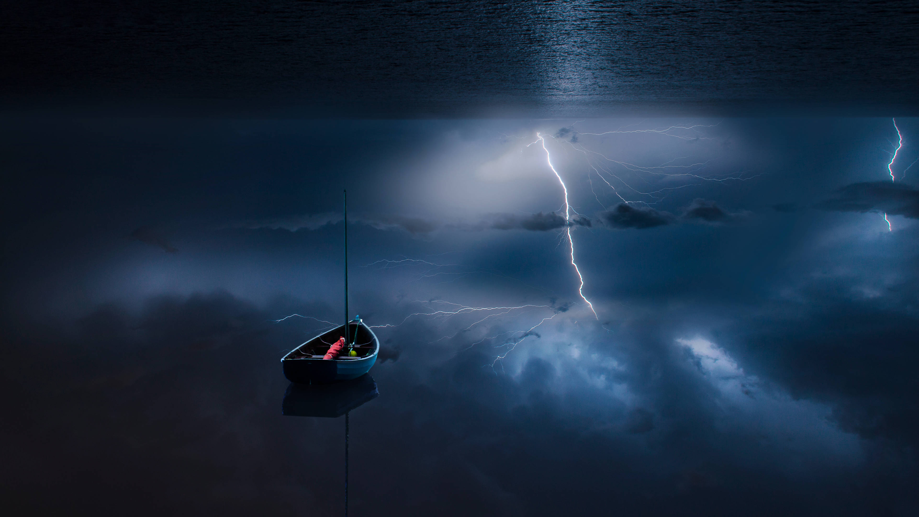 Windows 11 4K 桌布 壁紙 — 一艘孤獨的帆船漂浮在暴風雨的湖面上，鋸齒狀的閃電照亮了上方烏黑的雲層。