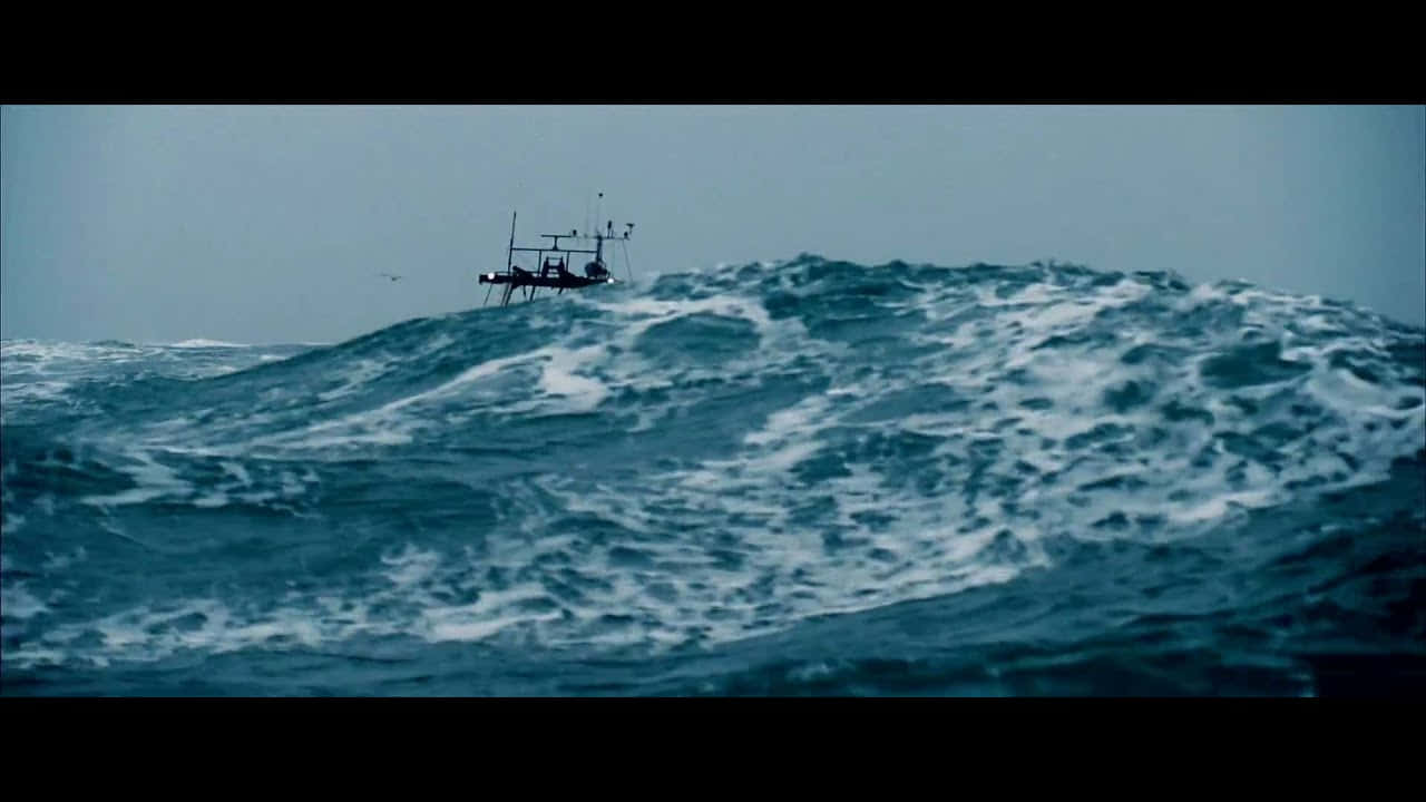Creepy Ocean 桌布 壁紙 — 一艘小漁船在灰色天空下與高聳翻騰的藍色海浪搏鬥。