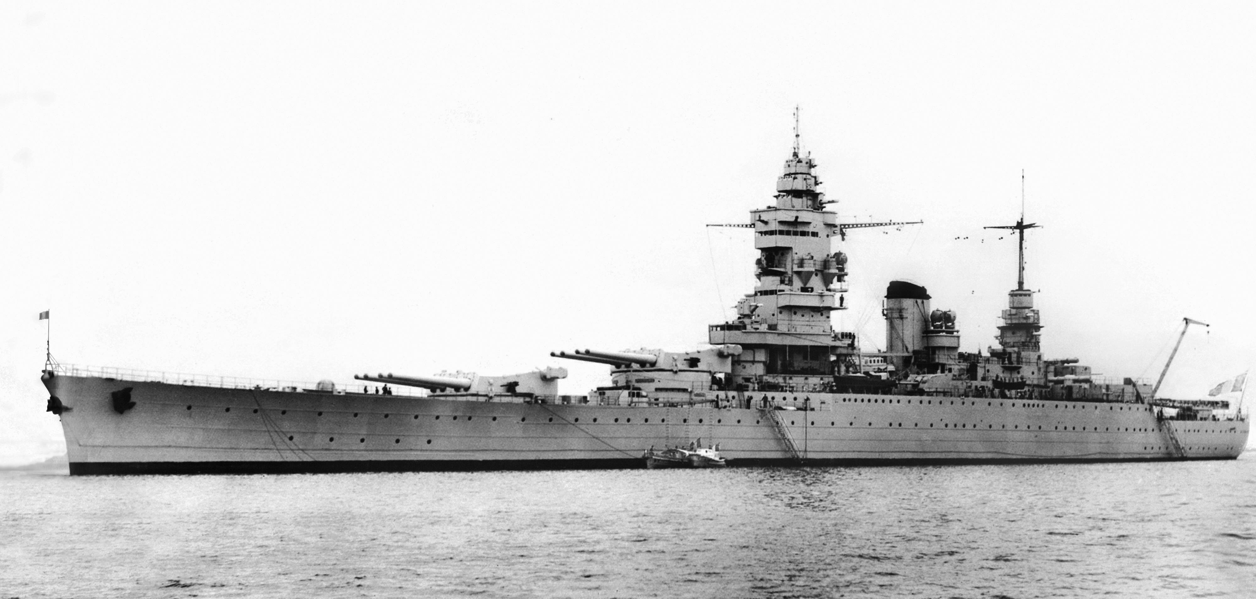 french 桌布 壁紙 — 一艘巨大的戰艦，擁有高聳的炮塔和複雜的上層建築，在平靜的水面上滑行，呈現出鮮明的黑白照片。