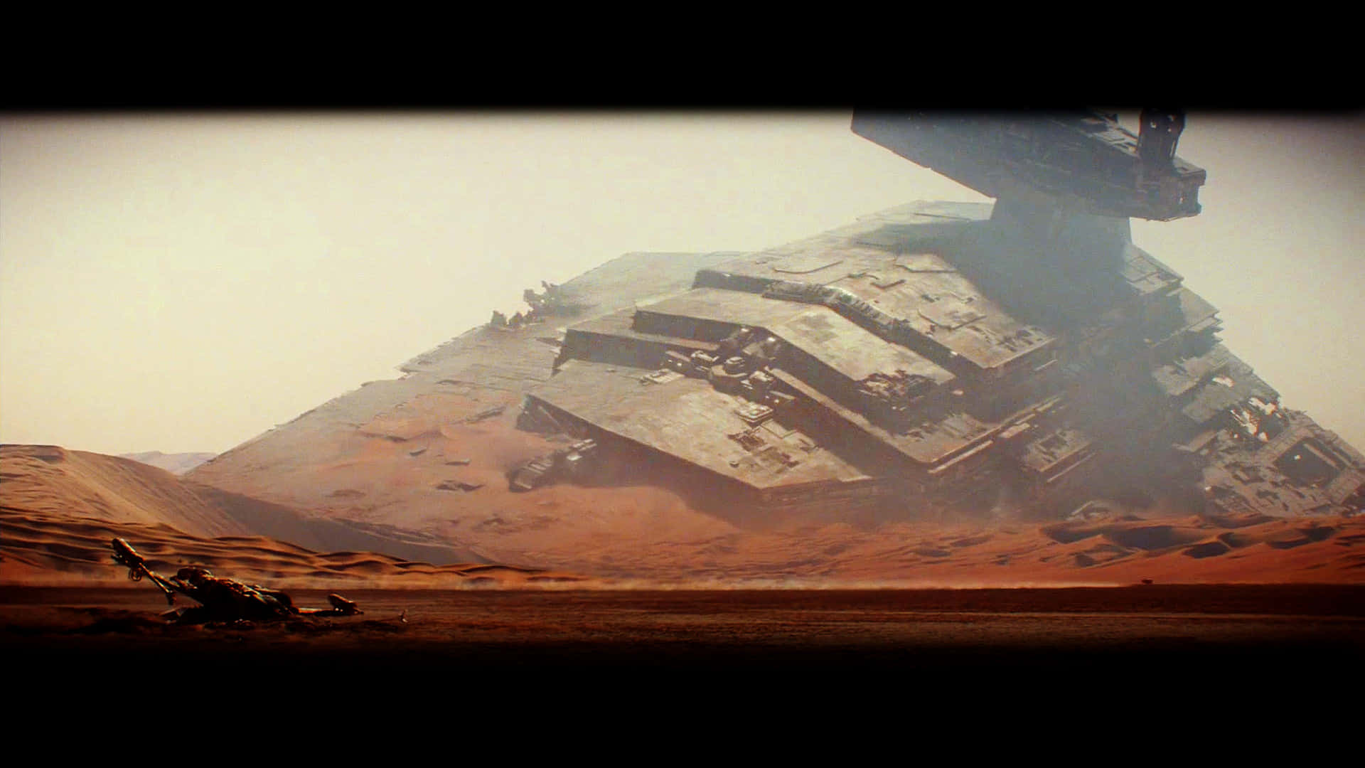 Star Wars The Force Awakens 桌布 壁紙 — 一艘巨大的星際毀滅者半埋在荒涼的紅色沙漠中，天空朦朧。