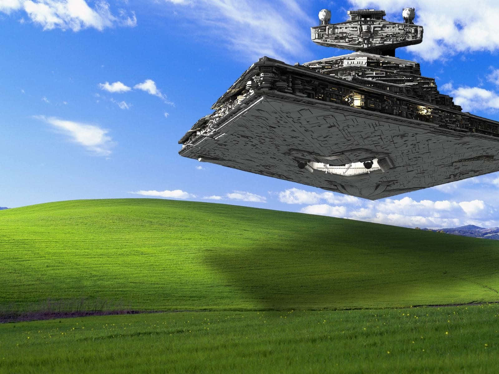 Windows XP 桌布 壁紙 — 一艘巨大的星際驅逐艦在晴朗藍天和蓬鬆白雲下，盤旋在生機勃勃的綠色山丘上空。