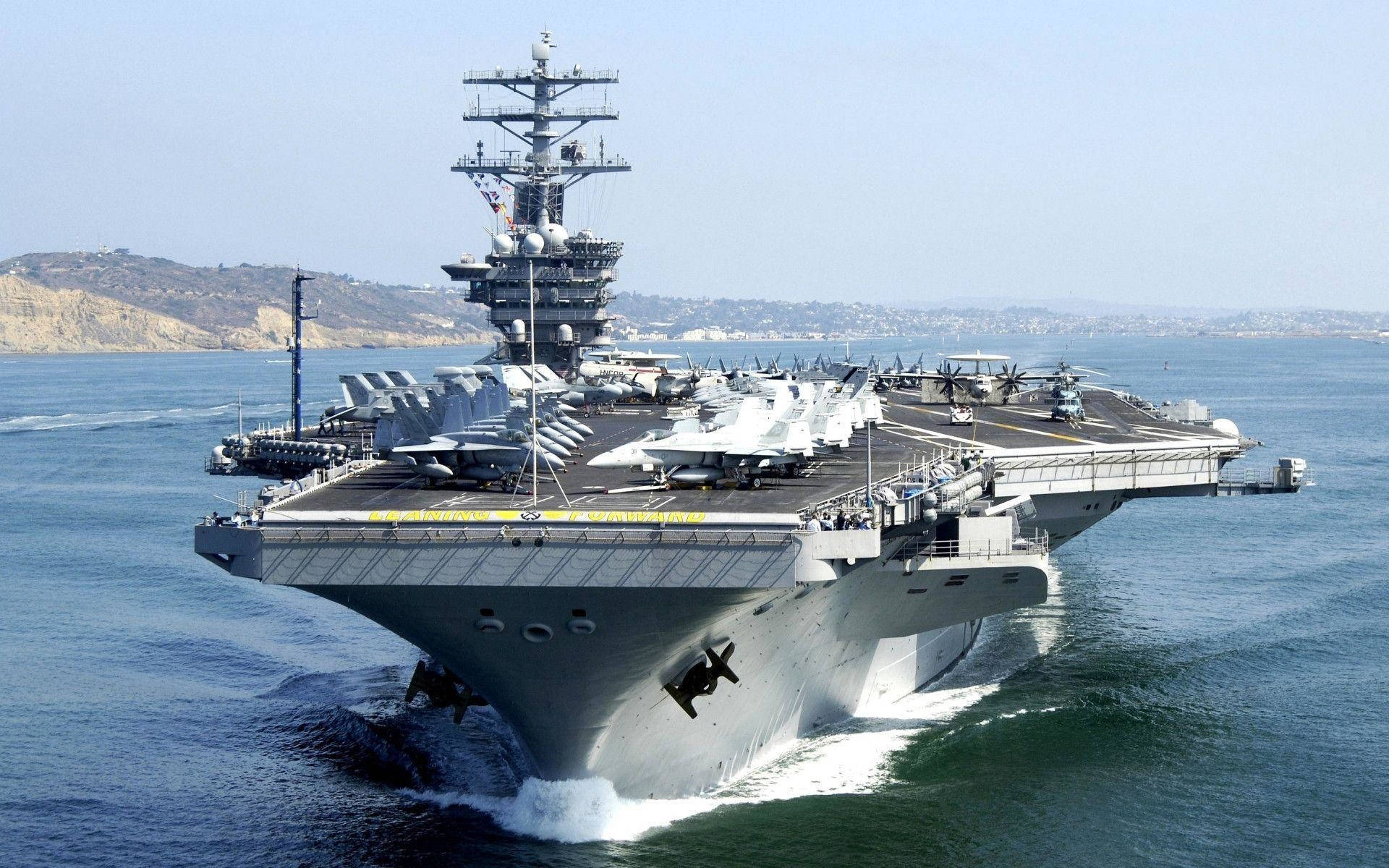 一艘大型航空母艦，甲板上有戰鬥機，在藍色海洋中航行。