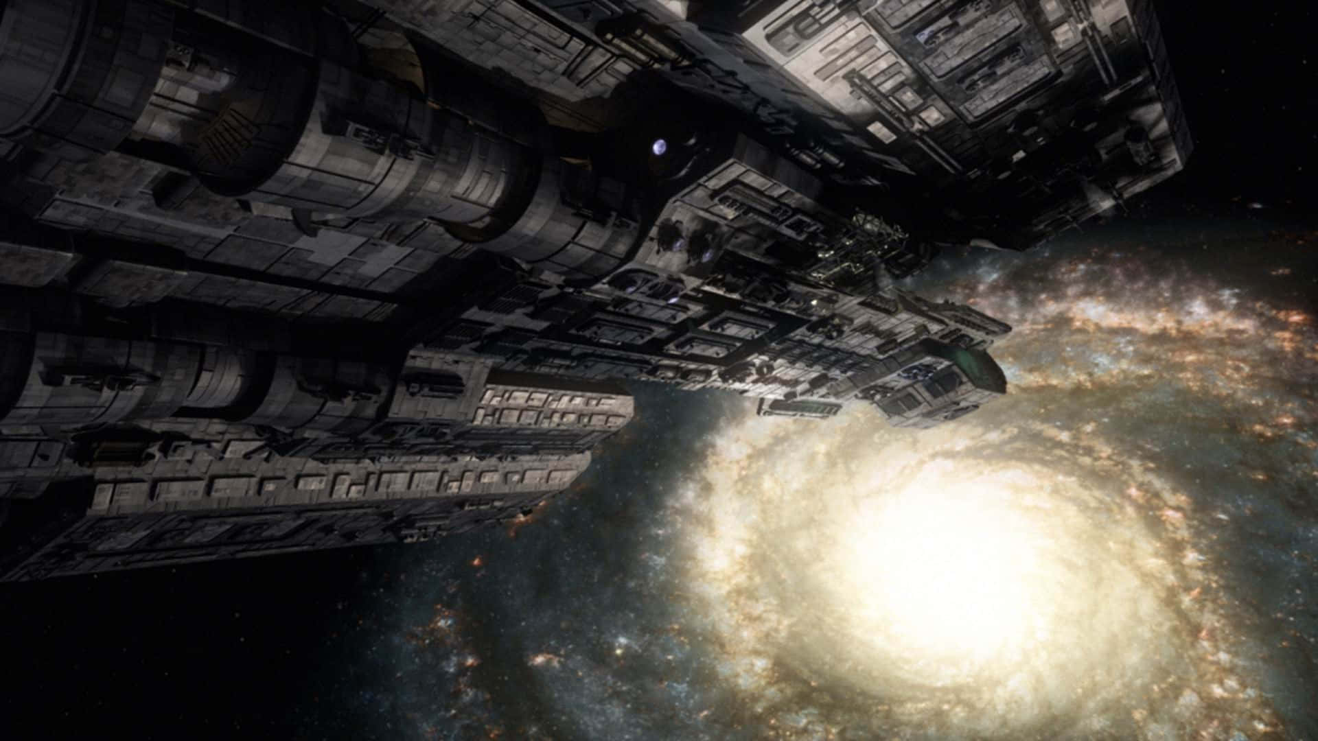 Stargate 桌布 壁紙 — 一艘巨大而細節豐富的太空船在充滿恆星的虛空中，穿過一個充滿活力的星系的發光螺旋臂漂流。