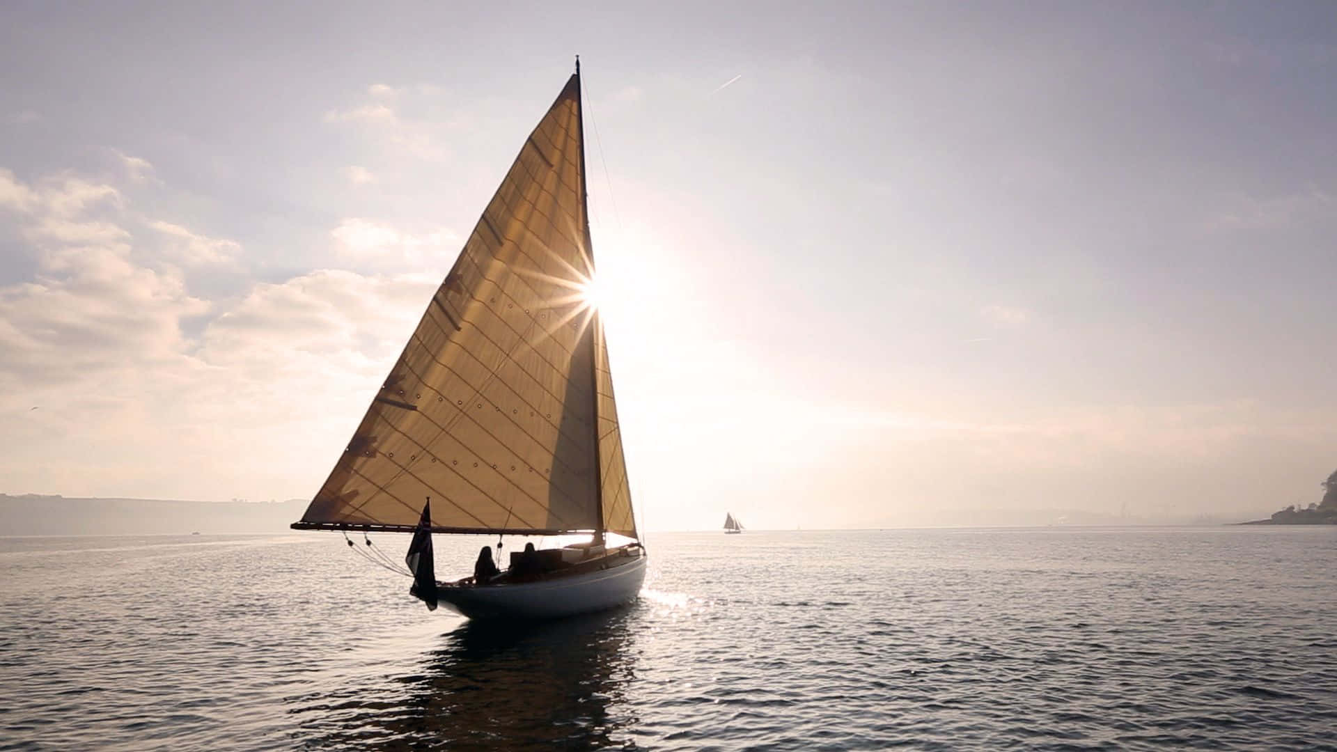 Sailboat 桌布 壁紙 — 一艘帆船在平靜的水面上滑行，太陽穿過帆布產生燦爛的星爆效果。