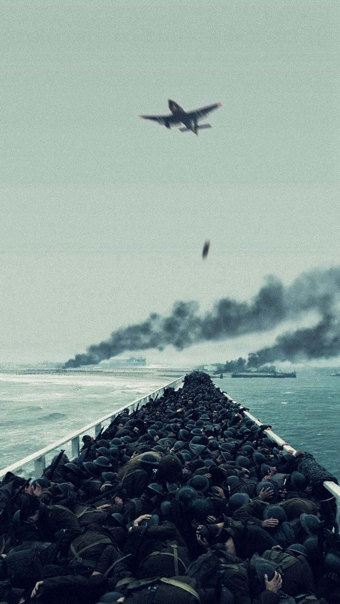 Ww2 iPhone 桌布 壁紙 — 一艘擠滿士兵的船隻駛向遙遠的戰場，同時一架飛機在煙霧瀰漫的水面上投下炸彈。