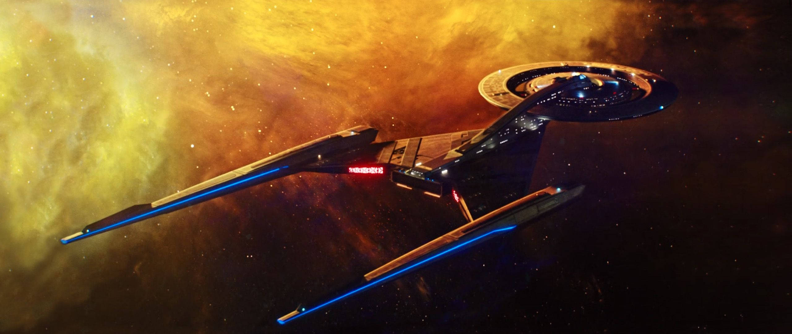 Discovery 桌布 壁紙 — 一艘星艦滑過充滿活力的星雲，其中有發光的橙色和黃色雲層以及散落的星星。