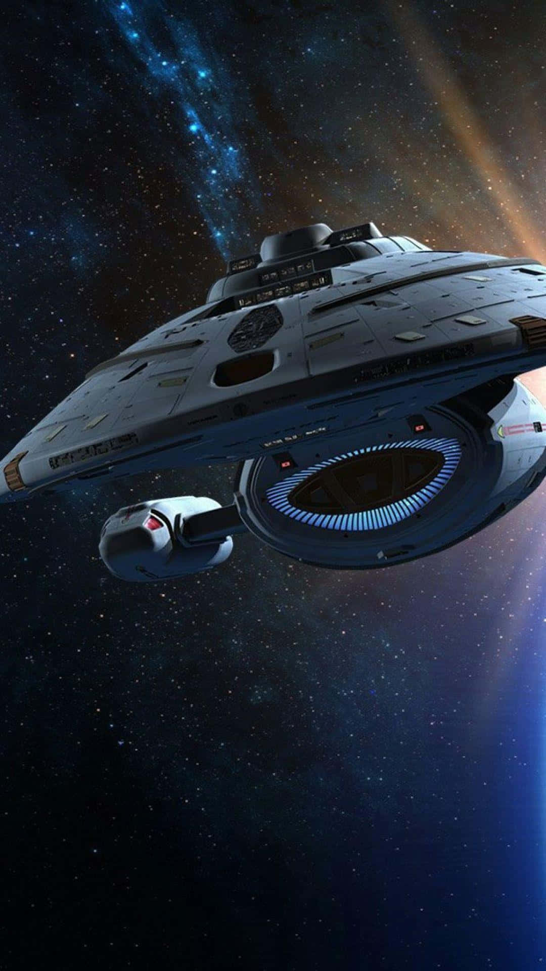 星際爭霸戰 桌布 壁紙 — 一艘未來風格的星艦在充滿活力的星雲中滑行，發光的藍色和橙色宇宙射線照亮其金屬船體。