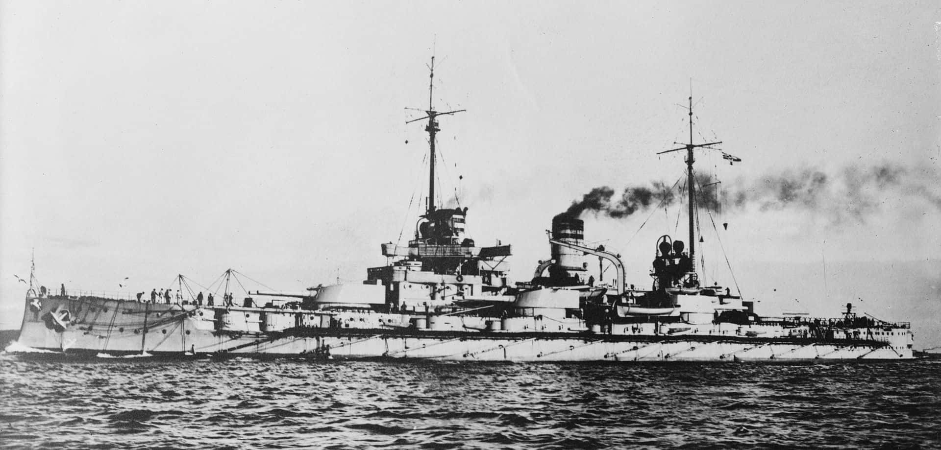 Battleships 桌布 壁紙 — 一艘歷史戰艦在波濤洶湧的海面上航行，煙囪冒出滾滾濃煙，呈現出一張清晰的黑白照片。