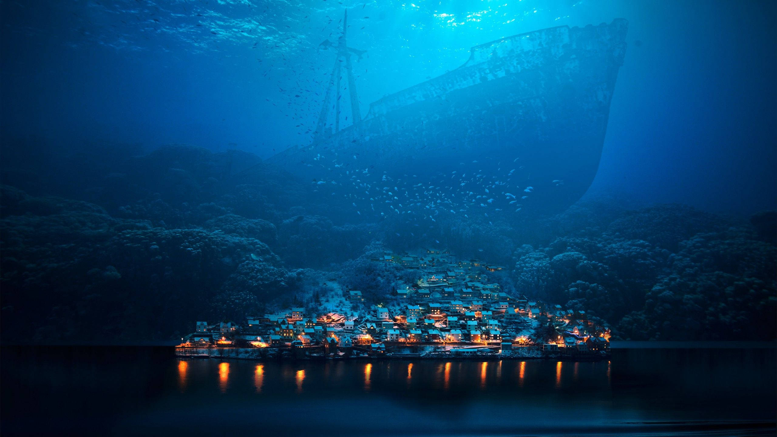 Aquatic 桌布 壁紙 — 一艘沉船在夜間水下籠罩著發光的沿海村莊，周圍有珊瑚礁和魚群游動。