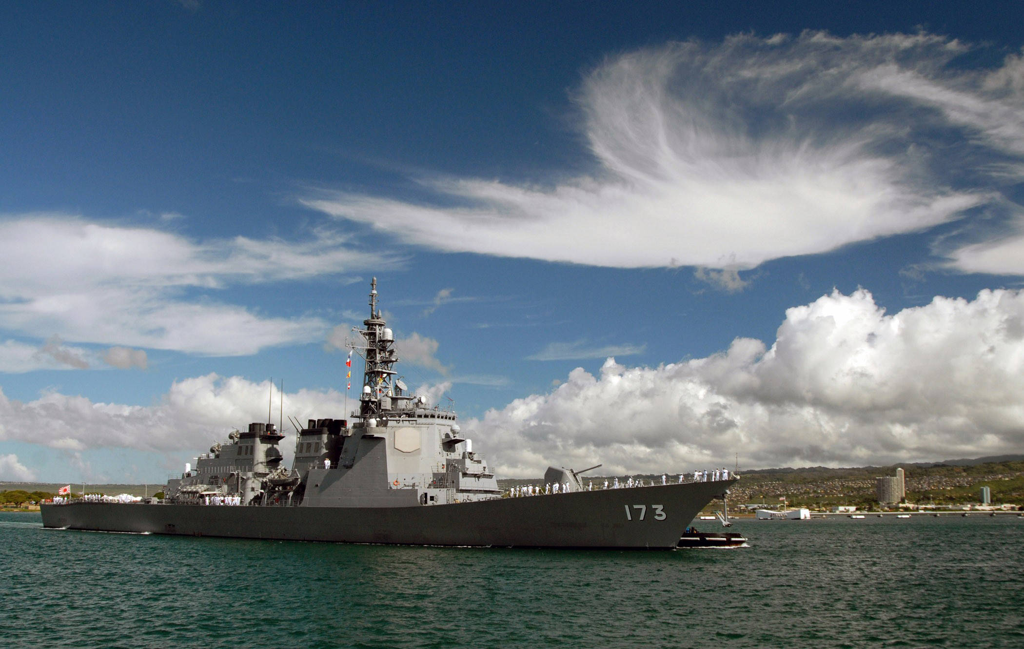 Warship 桌布 壁紙 — 一艘灰色海軍驅逐艦，船體編號173，在湛藍天空和戲劇性白雲下，平靜地航行在碧綠色的水面上。