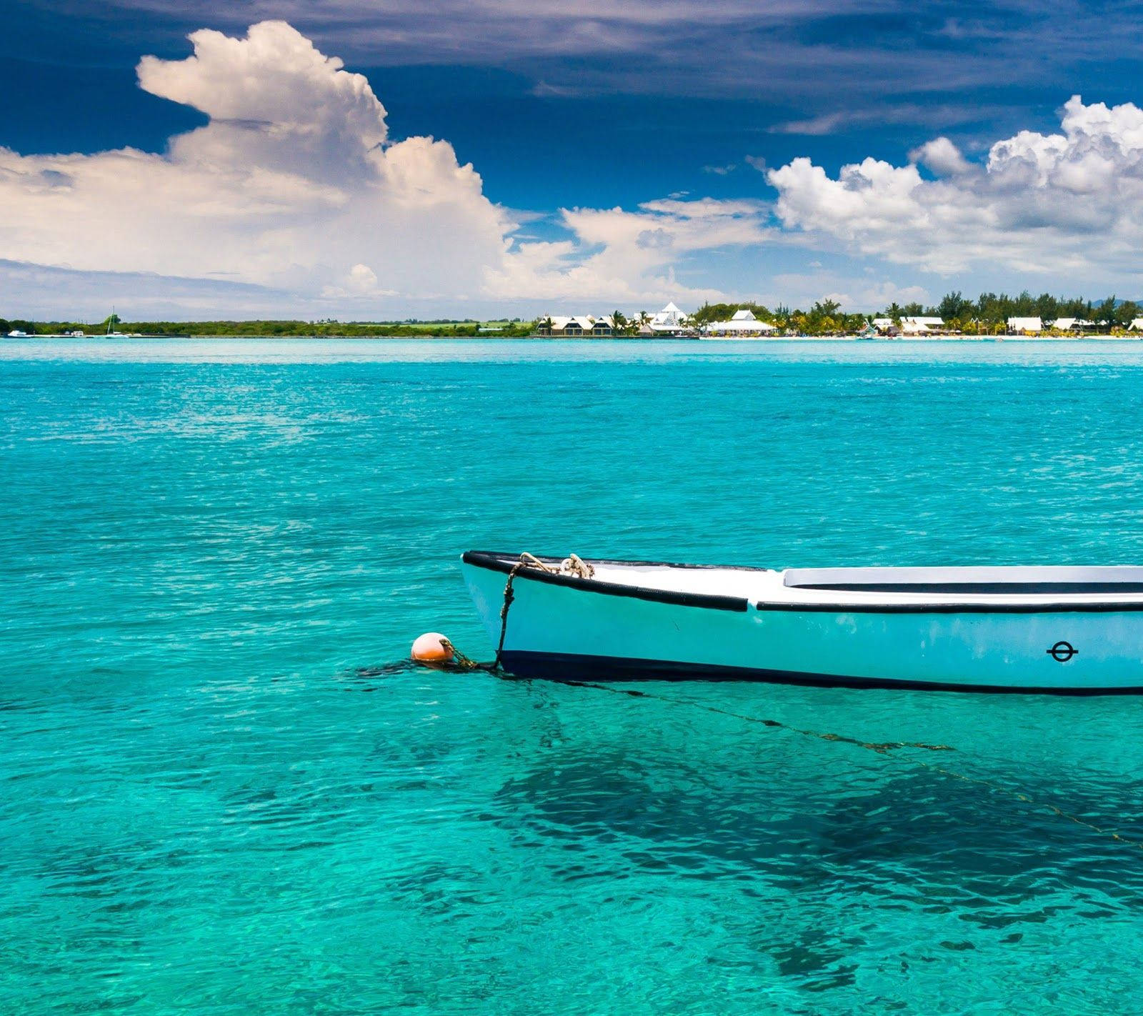 Mauritius 桌布 壁紙 — 一艘白色小船在清澈碧綠的海水中靜靜漂浮，天空湛藍，白雲朵朵。