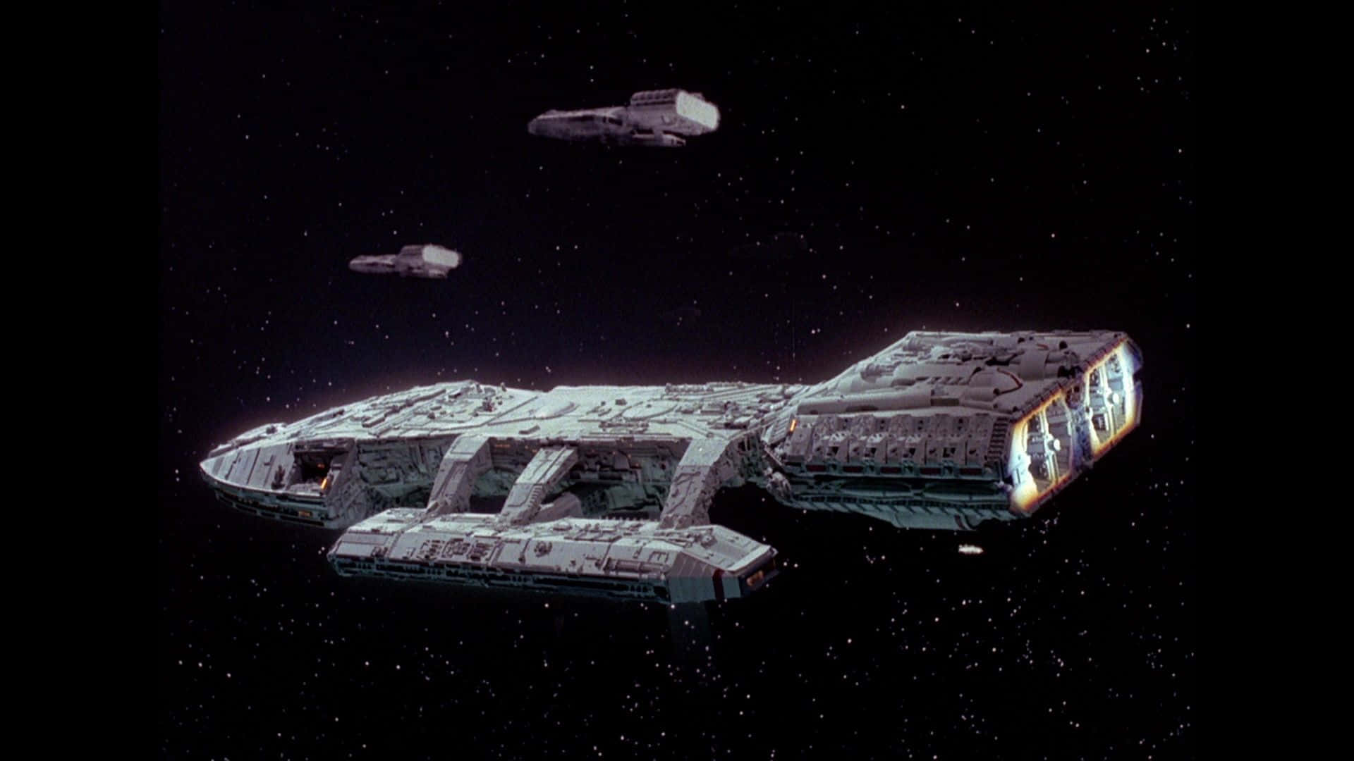 battlestar galactica 桌布 壁紙 — 一艘細節豐富的星艦，引擎發光，滑過星域，兩艘較小的船隻尾隨其後。