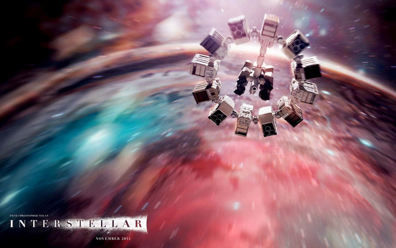 Interstellar Travel 桌布 壁紙 — 一艘配備機械臂的太空船繞著一條充滿活力的宇宙星雲運行，星雲上有紅色、藍色和藍綠色的條紋。