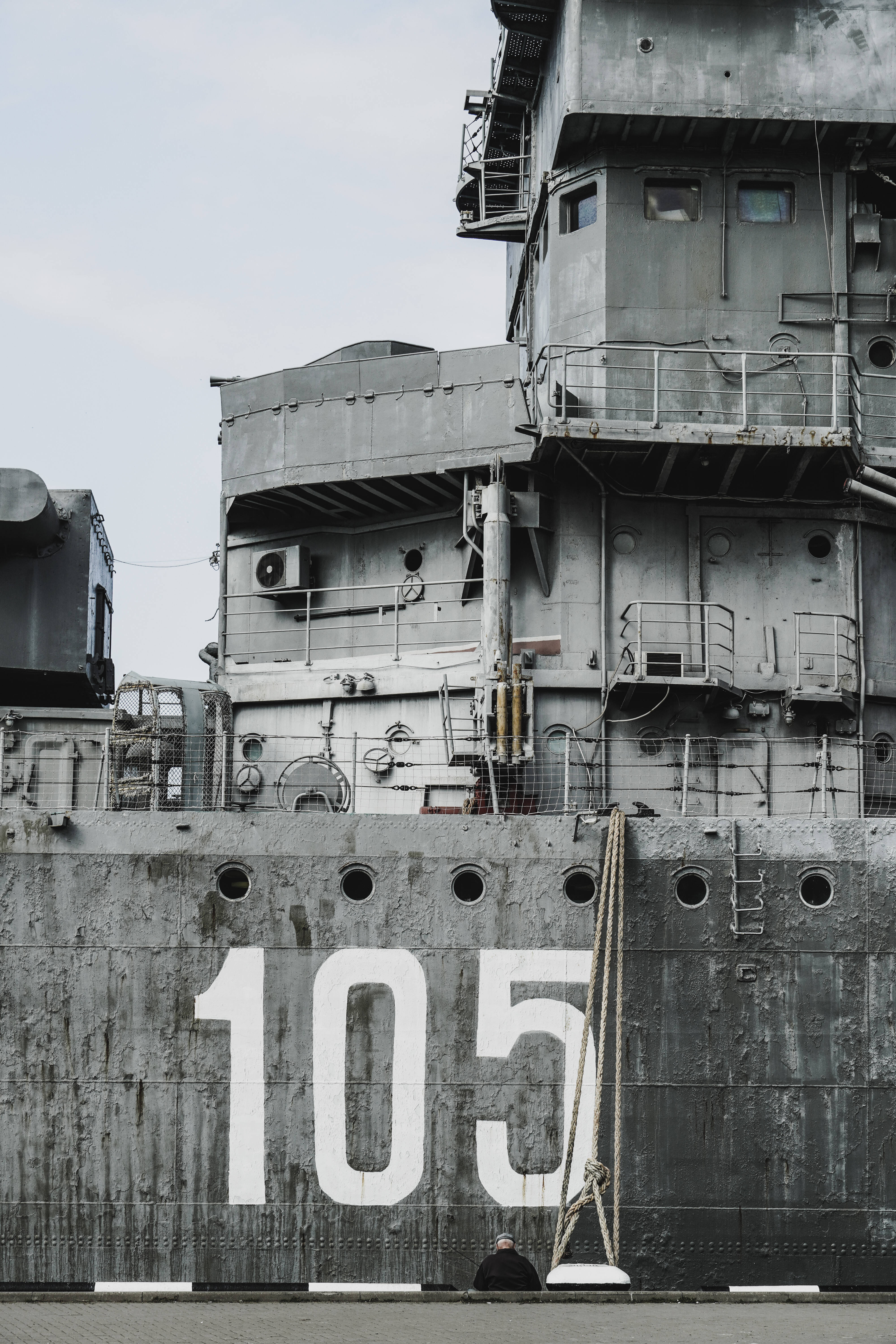 Warship 桌布 壁紙 — 一艘飽經風霜的軍艦，上面用粗體白色數字105，在陰天天空下佔據了畫面主導地位。