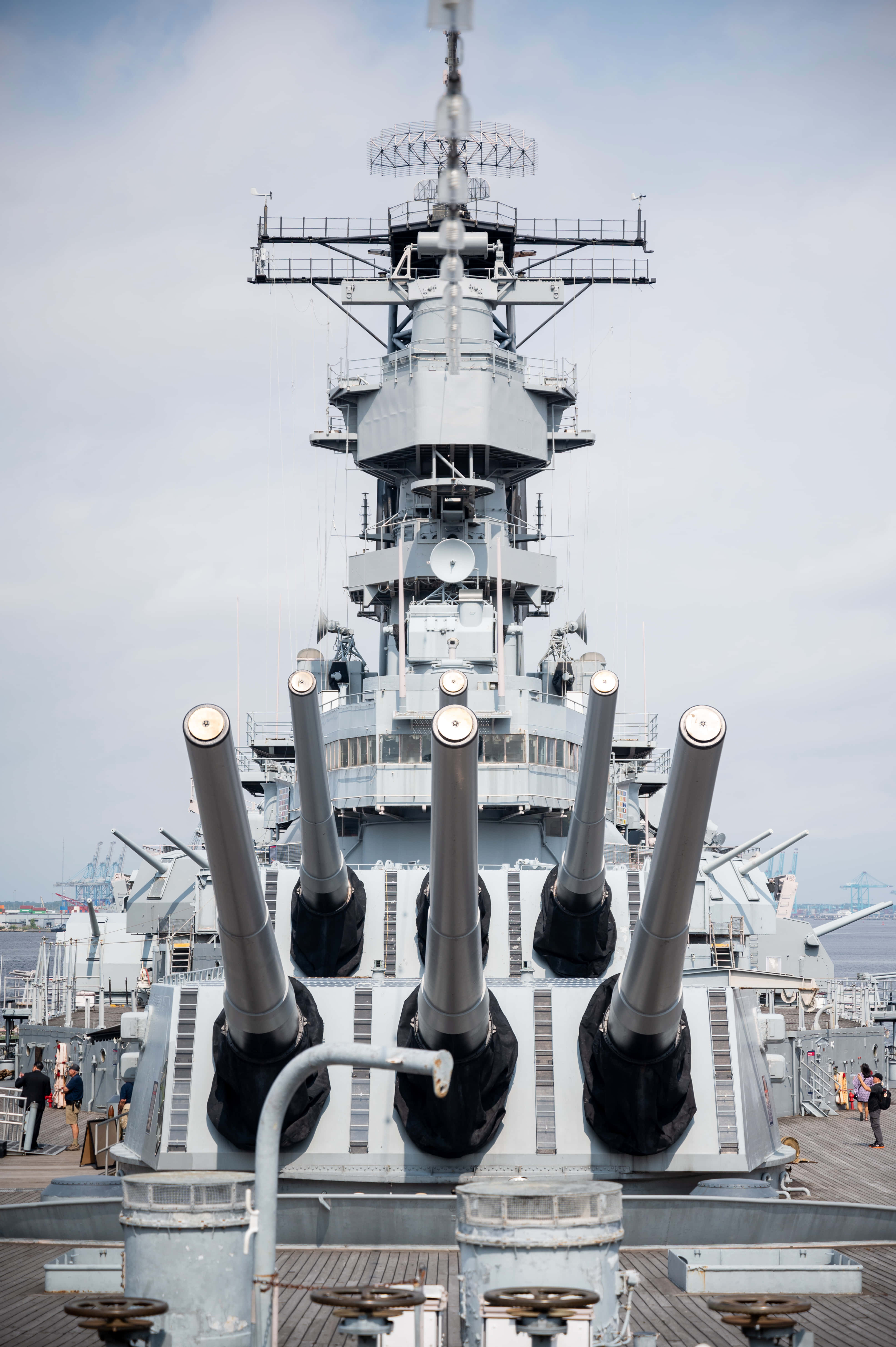 Battleships 桌布 壁紙 — 一艘高聳的戰艦，配備巨大的炮塔，在海軍博物館碼頭主宰著多雲的一天。