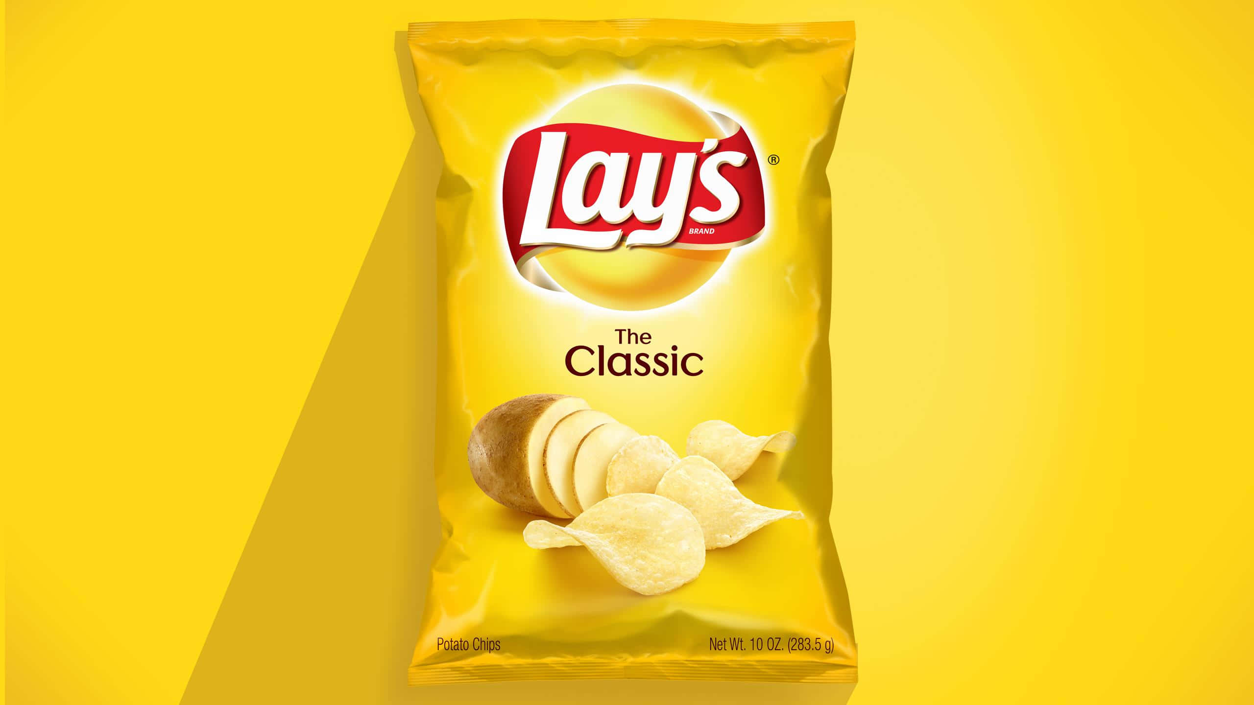 Snacks 桌布 壁紙 — 一袋亮黃色的Lay's Classic洋芋片居中放置在純黃色背景上，帶有柔和陰影。