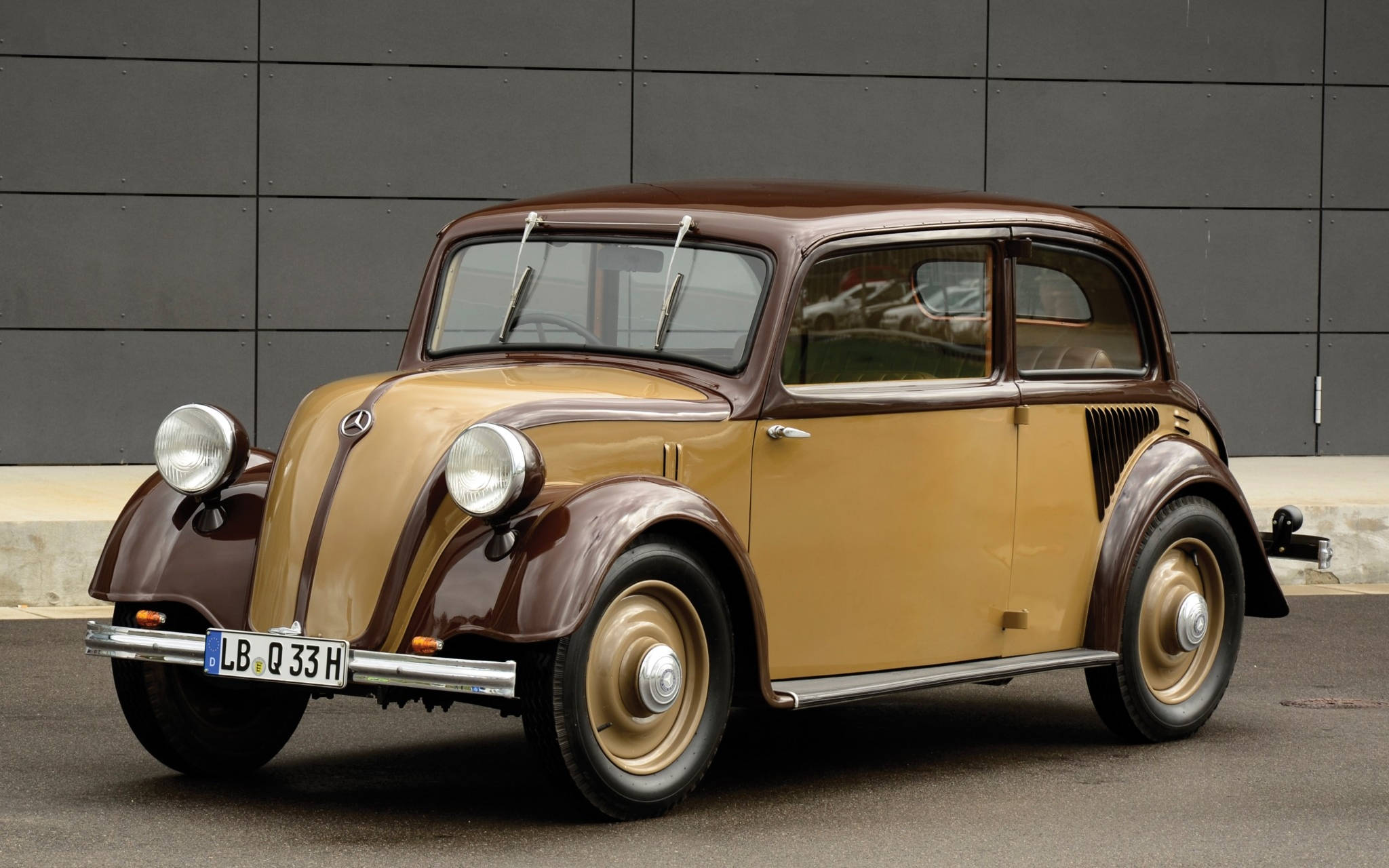 mercedes iPhone 桌布 壁紙 — 一輛1930年代的復古雙色棕褐色賓士300停放在灰色混凝土牆前。
