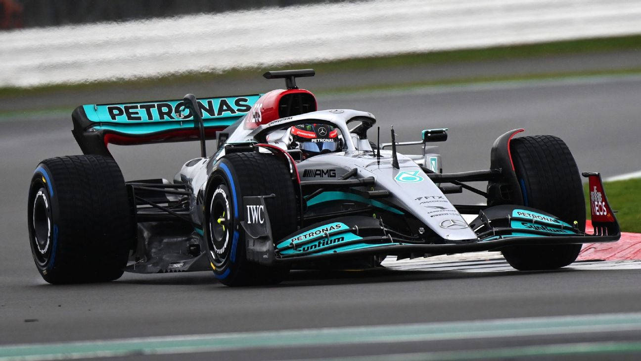 Racing 桌布 壁紙 — 一輛Mercedes-AMG Petronas一級方程式賽車在潮濕的賽道上疾馳，輪胎濺起水花。