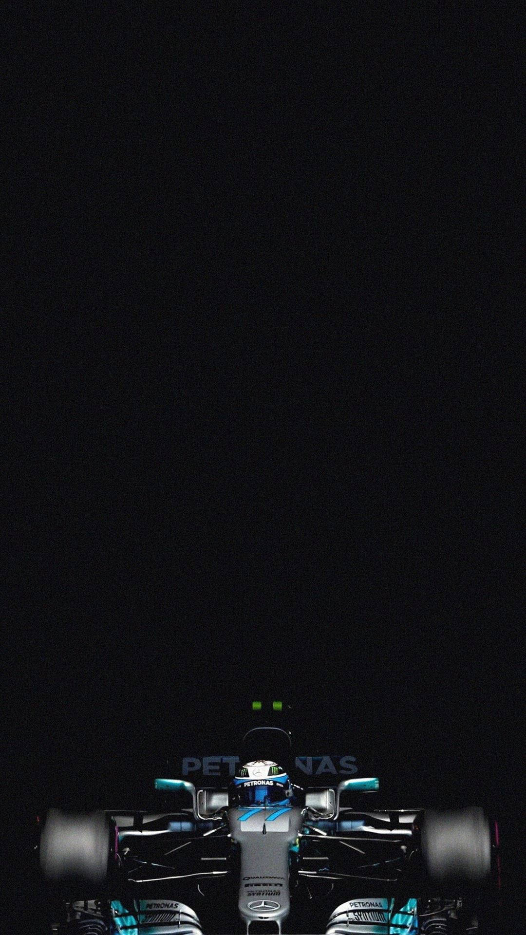 桌布 壁紙 — 一輛一級方程式賽車在漆黑背景上被聚光燈照亮，帶有發光的綠色燈光。