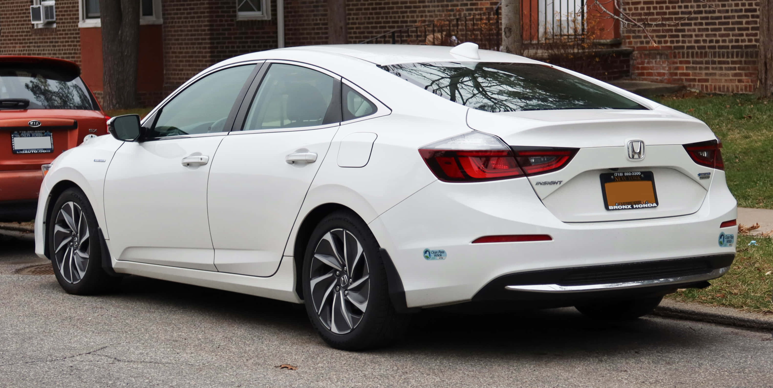 Honda Insight 桌布 壁紙 — 一輛乾淨的白色本田Insight混合動力轎車停放在磚房旁邊的住宅街道上。