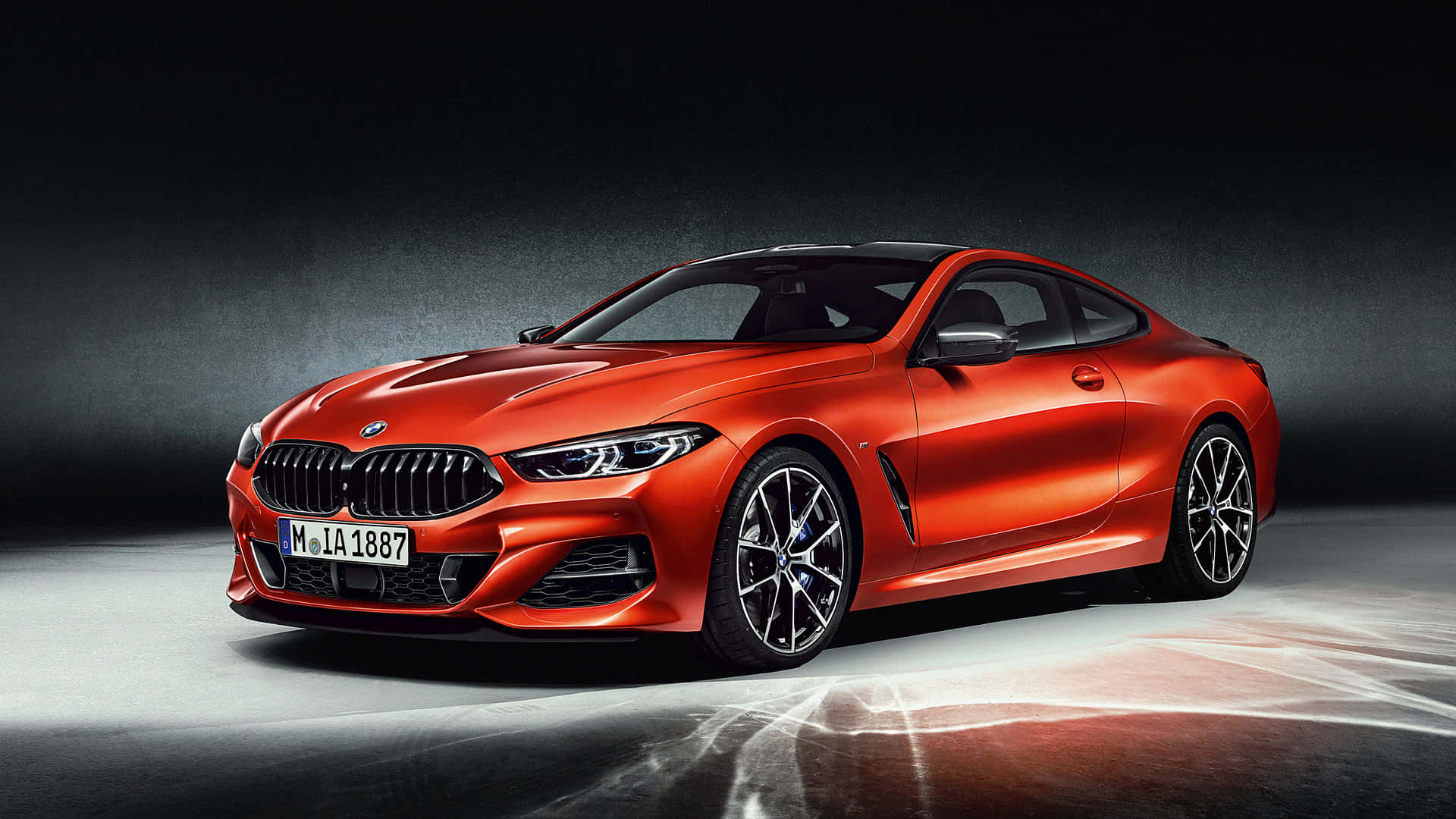 Bmw Laptop 桌布 壁紙 — 一輛亮橙色BMW 8系列轎跑車在攝影棚燈光下，在深色漸變背景上閃閃發光。