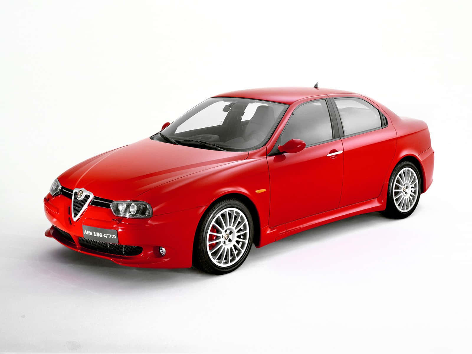 Alfa Romeo 156 桌布 壁紙 — 一輛亮紅色Alfa 156 GTA運動轎車以四分之三角度擺放在潔白的工作室背景前。