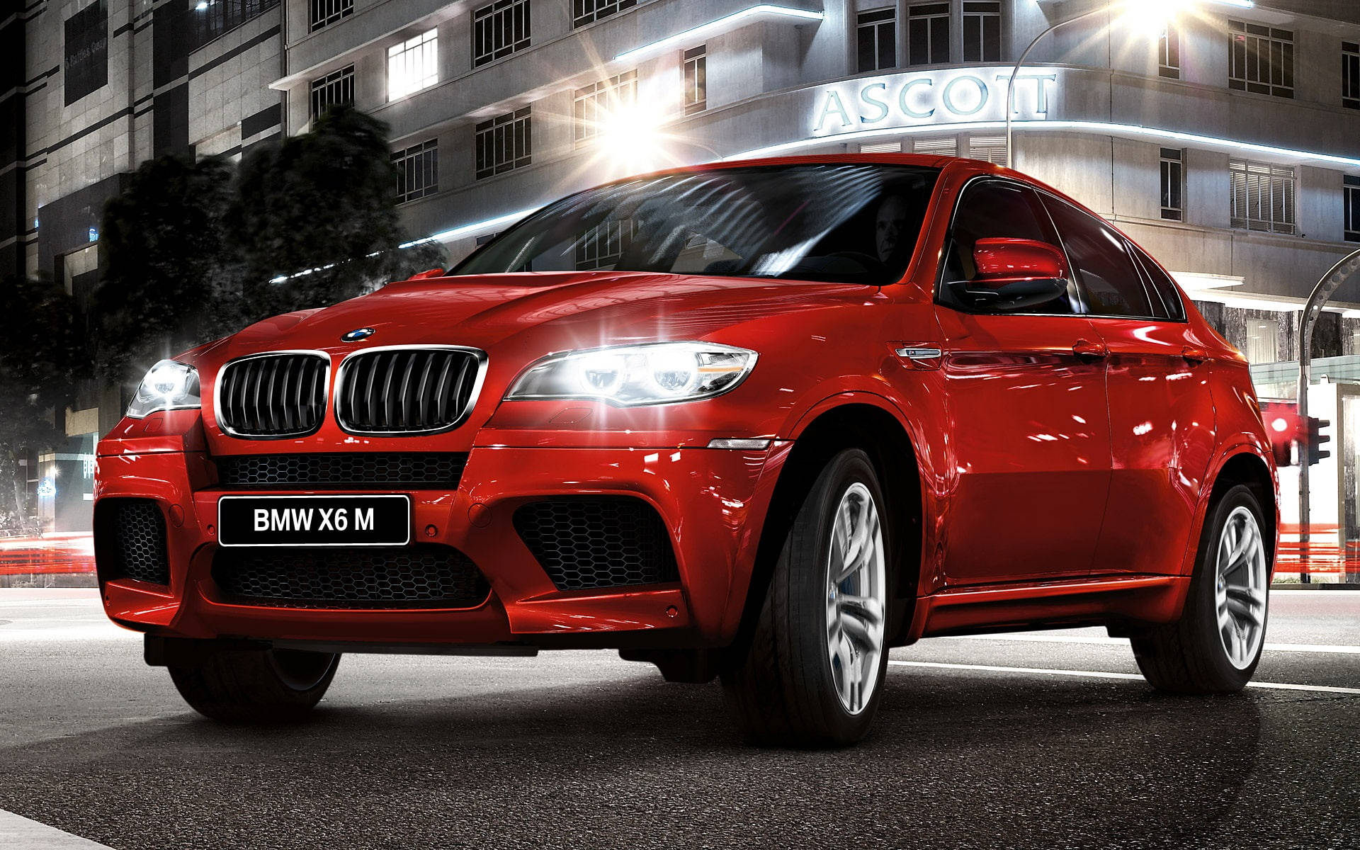 m 桌布 壁紙 — 一輛亮紅色BMW X6 M SUV在夜間濕滑的街道上閃耀著城市燈光，背景是一座燈火通明的建築物。