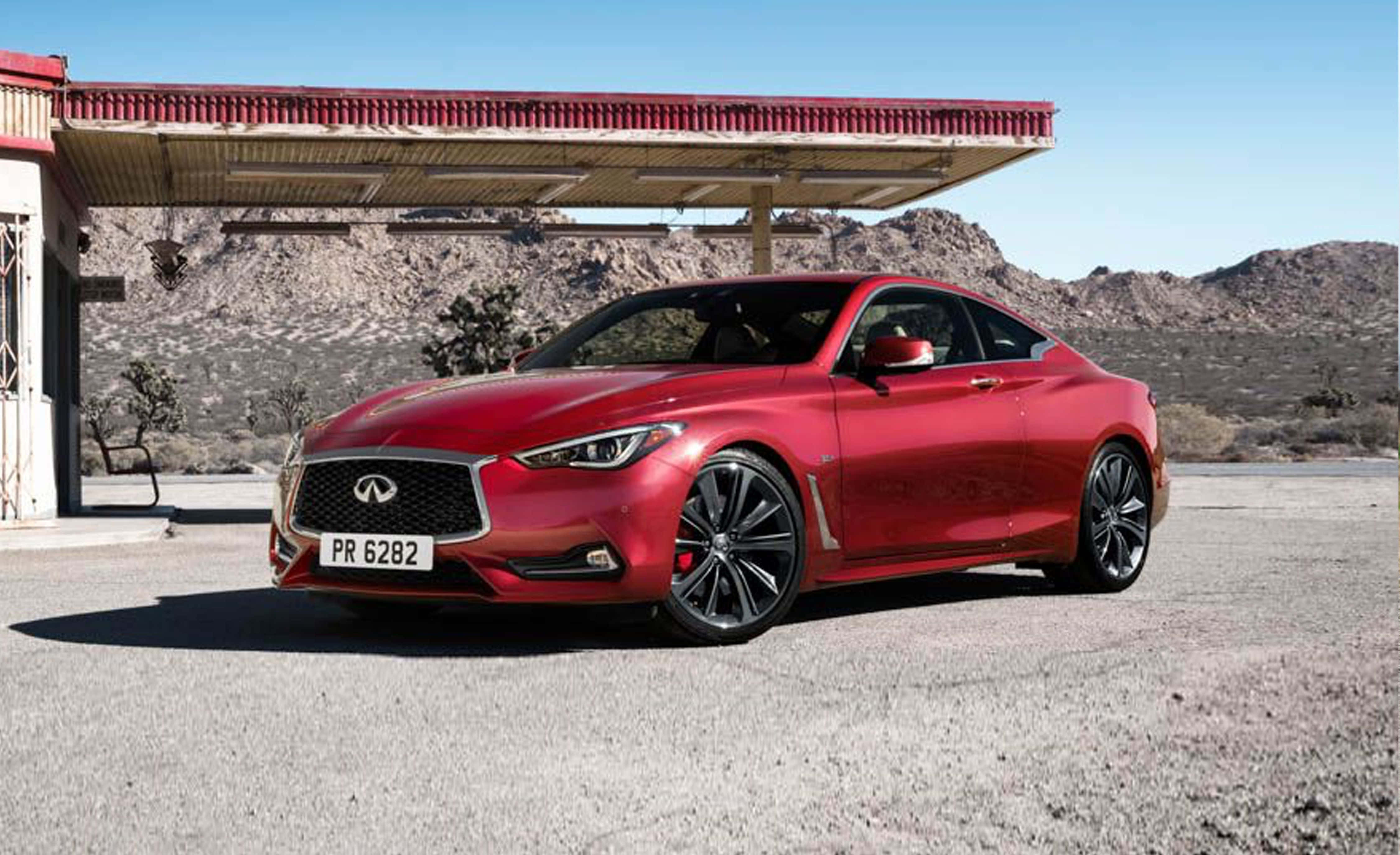 Infiniti Q60 桌布 壁紙 — 一輛亮紅色Infiniti跑車停泊在沙漠加油站，天空清澈湛藍。
