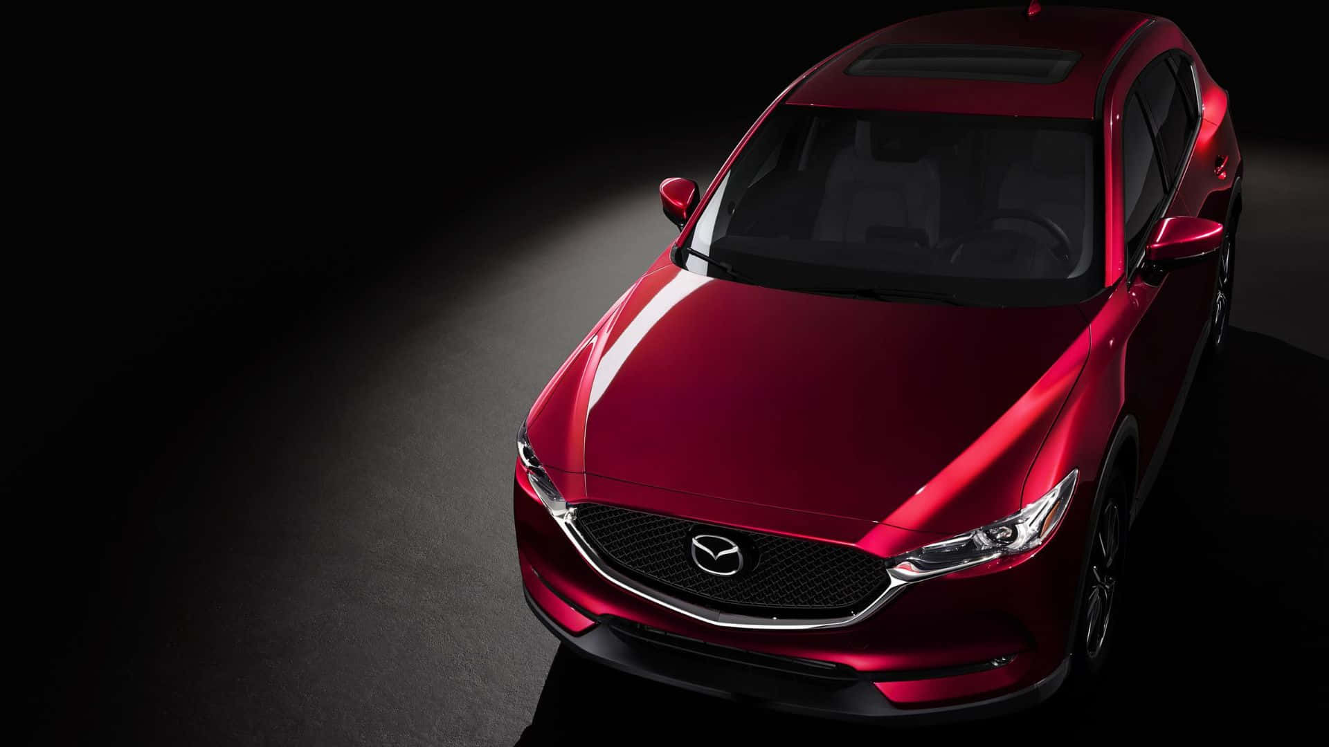 Mazda Cx-5 桌布 壁紙 — 一輛亮紅色Mazda SUV在黑暗工作室背景中被聚光燈照亮。