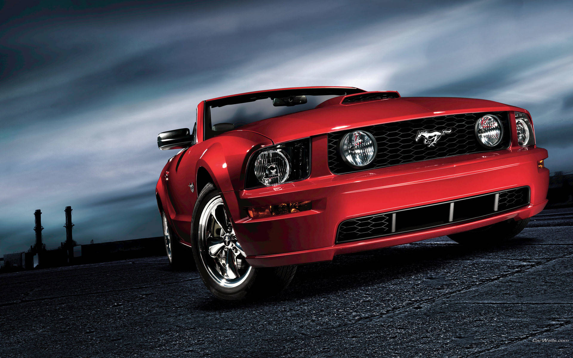 mustang HD 桌布 壁紙 — 一輛亮紅色可摺疊車頂的Mustang跑車停泊在黑暗的瀝青停車場上，天空陰沉暴風雨。