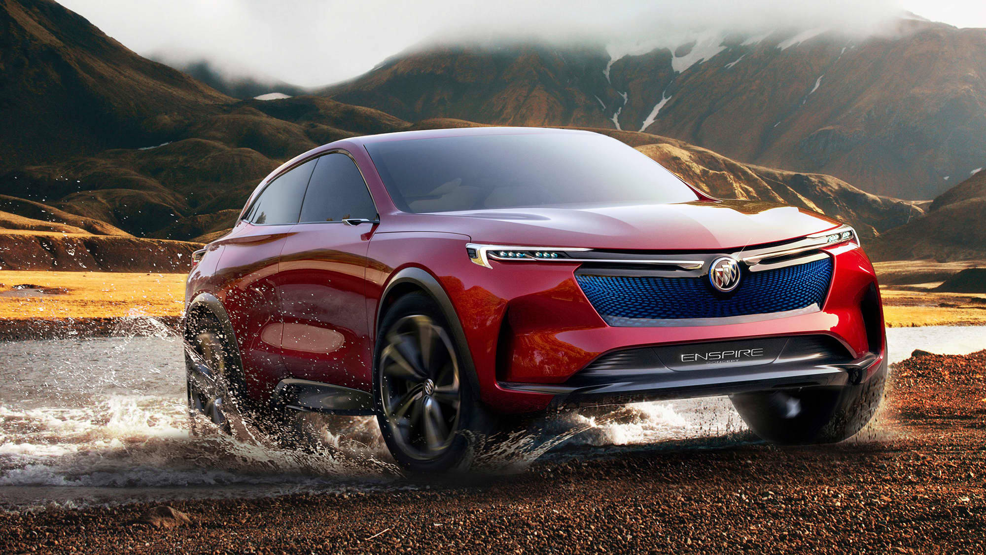 Buick 桌布 壁紙 — 一輛亮紅色的Buick Enspire SUV在泥濘的小溪中飛馳，背景是霧氣瀰漫的山巒。