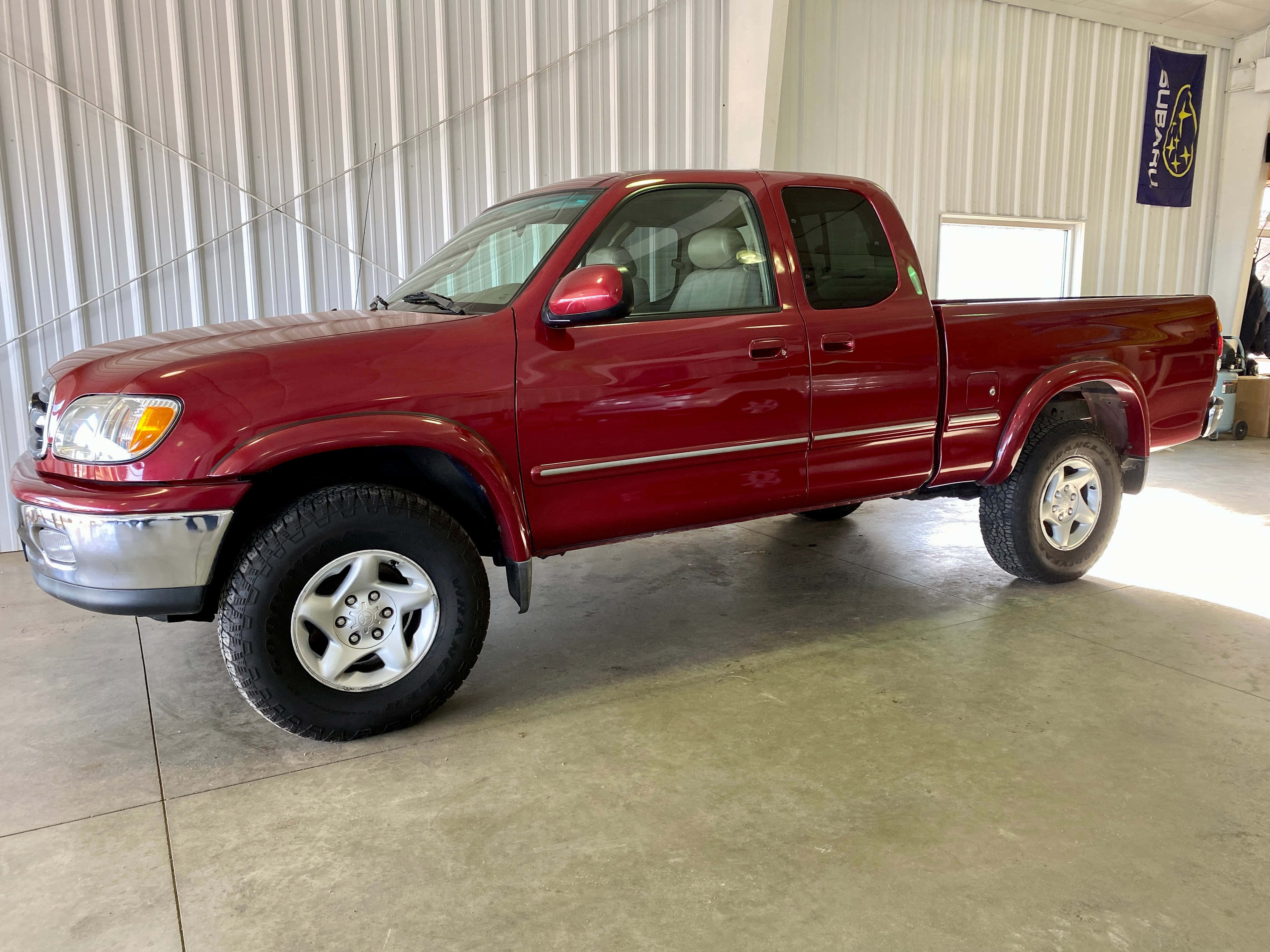 Pickup Truck 桌布 壁紙 — 一輛亮紅色的豐田Tacoma pickup truck停放在光線充足、金屬牆面及混凝土地板的車庫內。