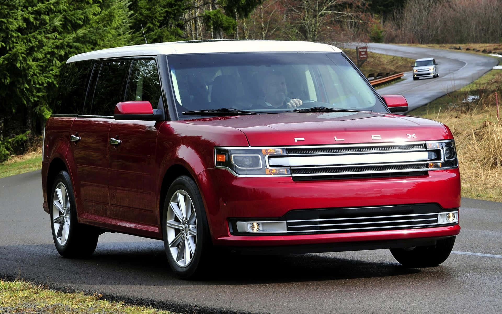 Ford Flex 桌布 壁紙 — 一輛亮紅色福特Flex SUV在濕滑的森林道路上行駛，遠處可見另一輛車。