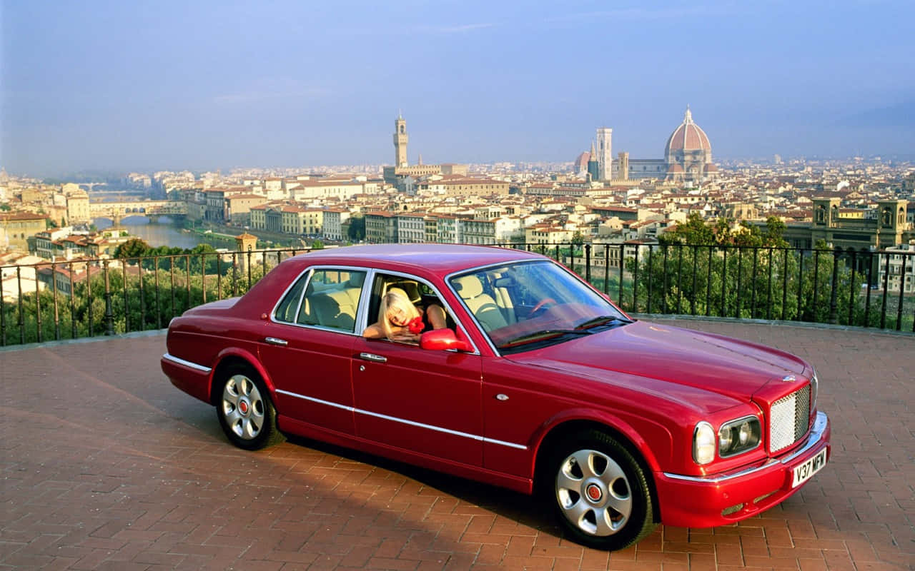 Bentley Arnage 桌布 壁紙 — 一輛亮紅色賓利 Arnage 停泊在俯瞰佛羅倫斯的露台上，背景可見聖母百花大教堂。