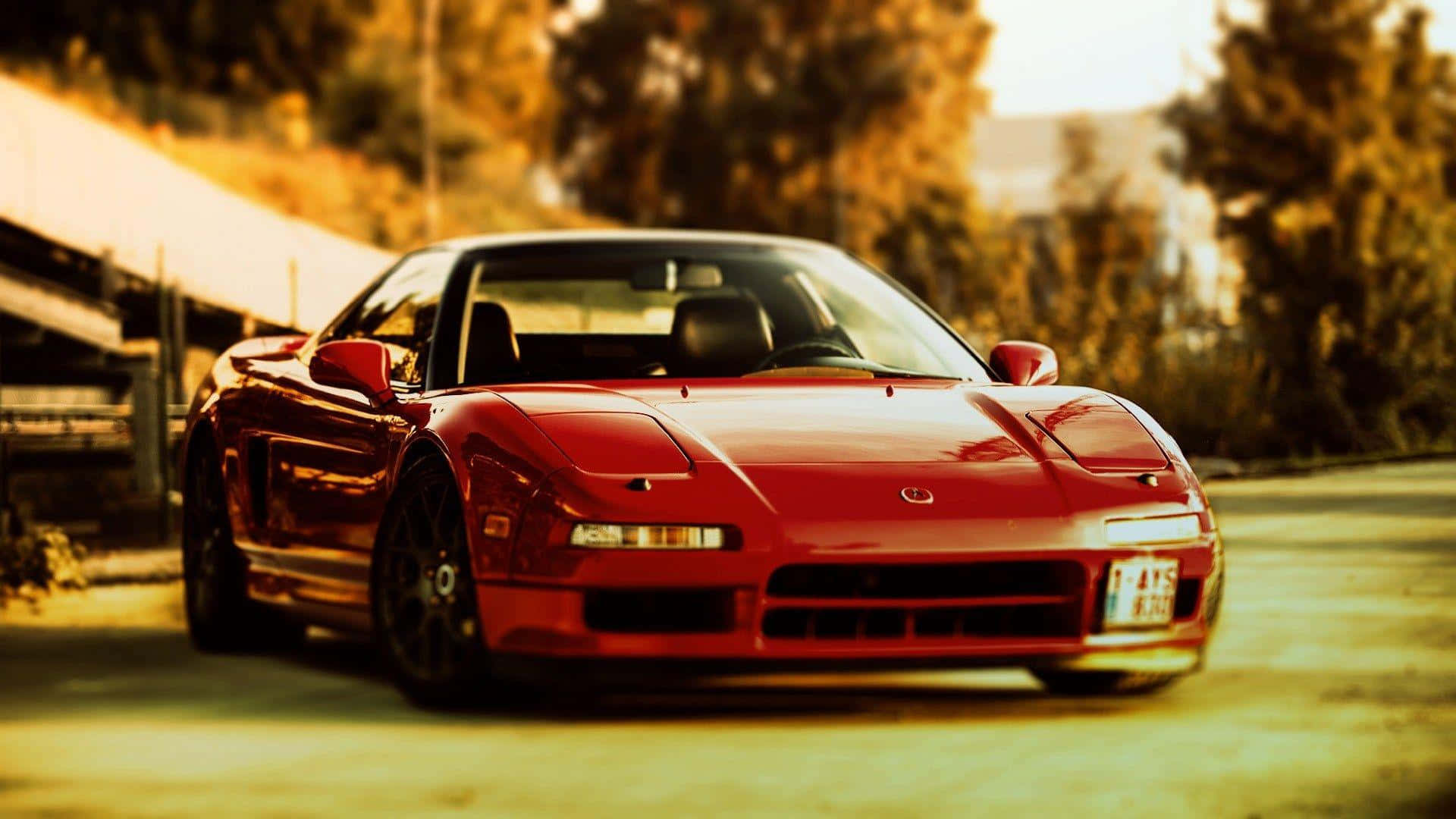 Acura Integra 桌布 壁紙 — 一輛亮紅色跑車停泊在陽光明媚的道路上，背景是金色的樹葉。