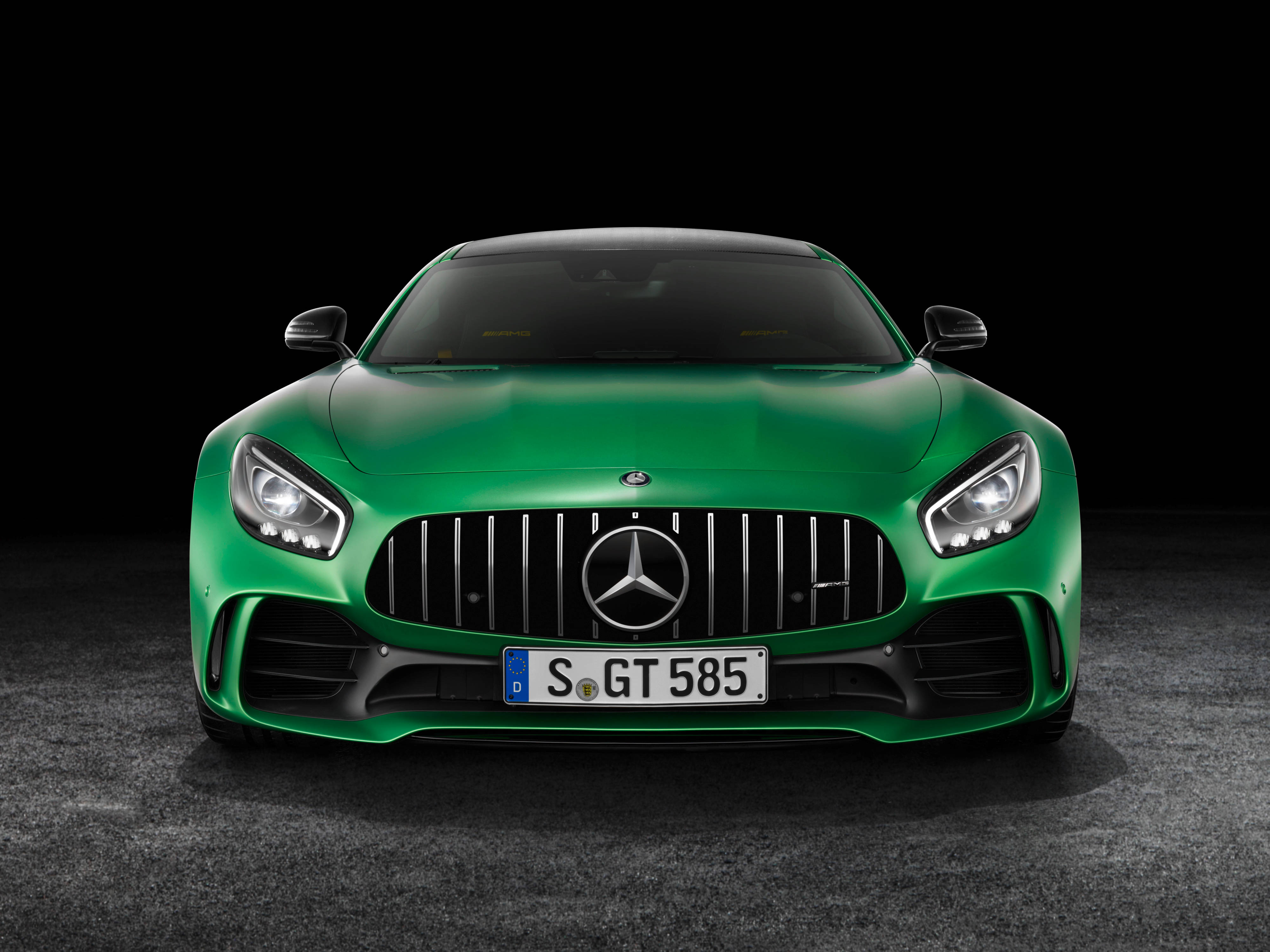 Gtr 桌布 壁紙 — 一輛亮綠色Mercedes-AMG GT跑車正面朝前，配備鋒利頭燈和黑色格柵，背景為深色攝影棚。