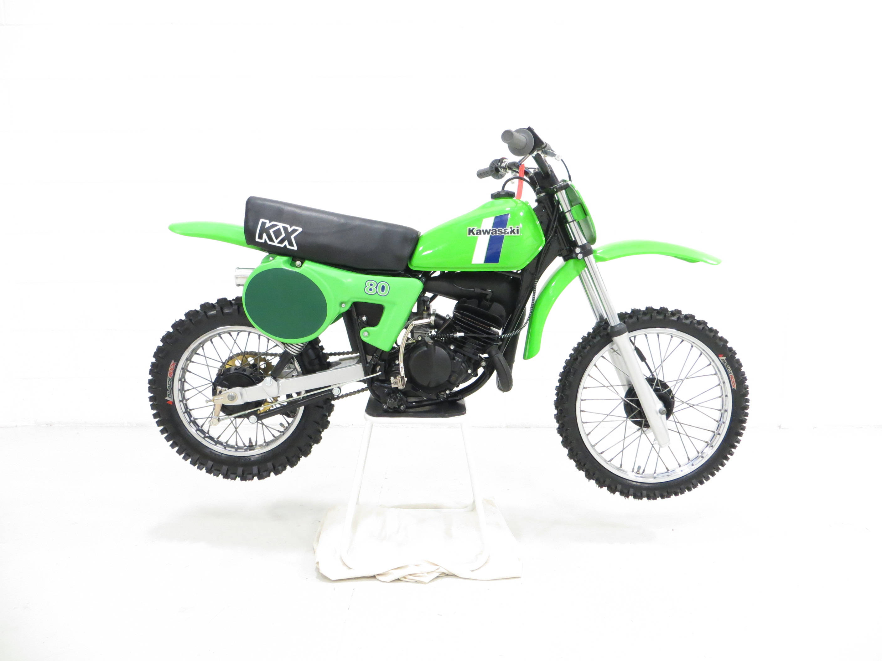 腳踏車 桌布 壁紙 — 一輛亮綠色的Kawasaki KX80越野摩托車站在白色支架上，背景是純白色。
