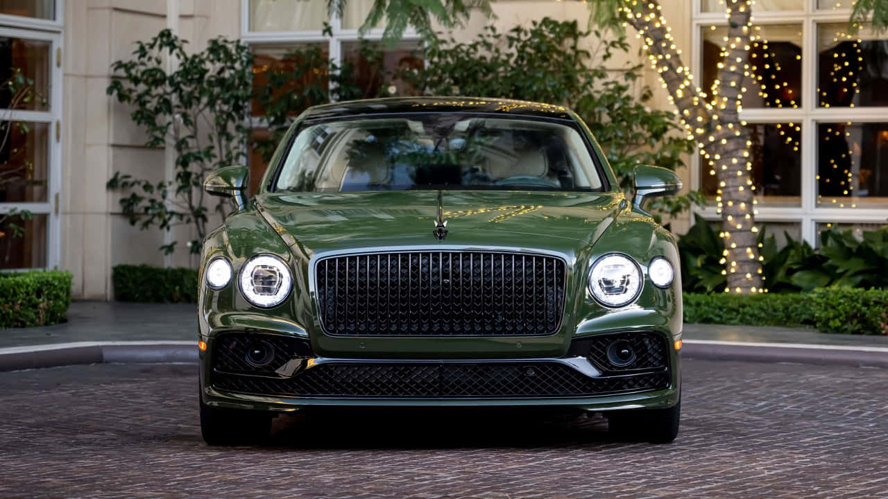 Bentley Flying Spur 桌布 壁紙 — 一輛亮綠色賓利Bentayga停在鵝卵石車道上，後面樹上掛著節日燈串。