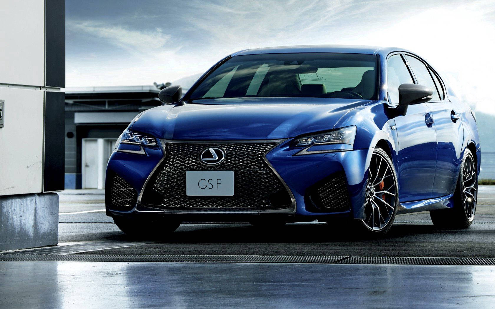 i give up 桌布 壁紙 — 一輛亮藍色Lexus GS F運動房車停在潮濕的混凝土表面上，天空多雲。