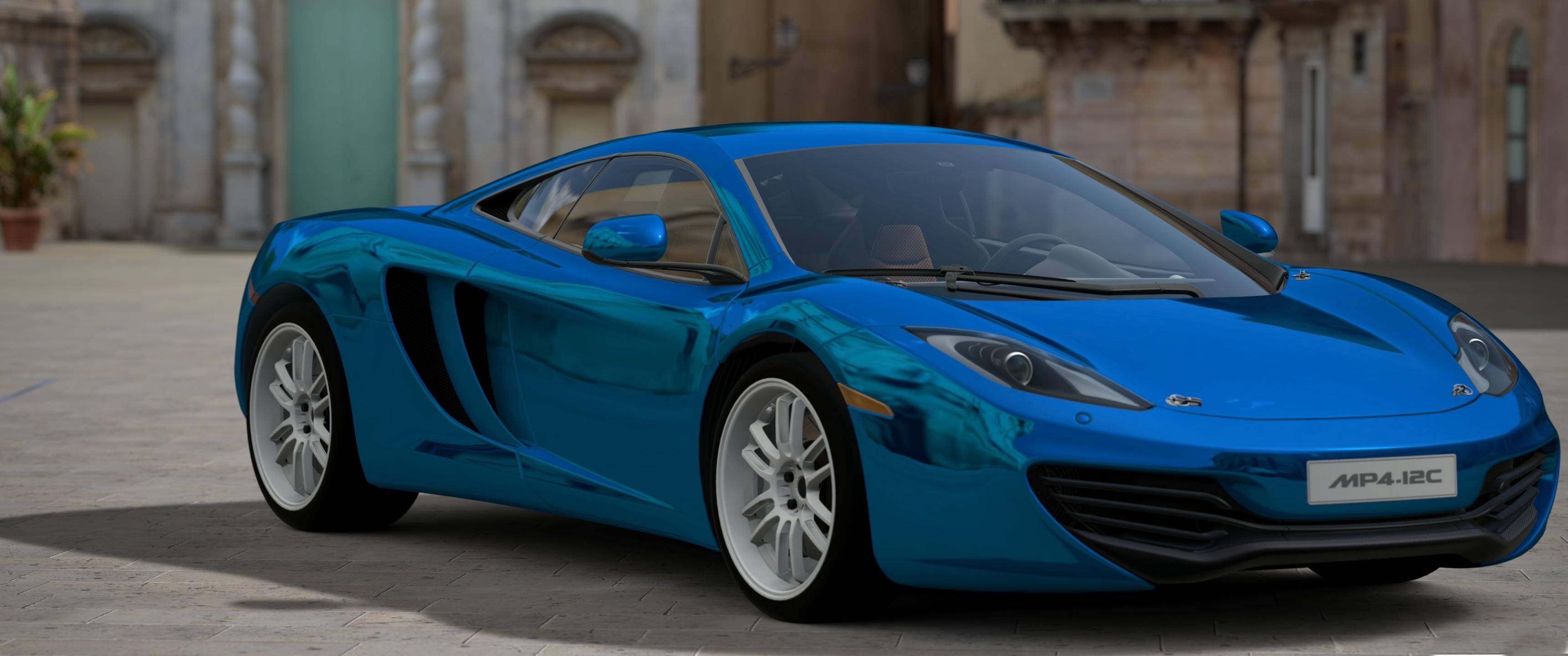 Cool Car 桌布 壁紙 — 一輛亮藍色McLaren MP4-12C跑車停放在陽光普照的石砌廣場上，背景是歷史建築。
