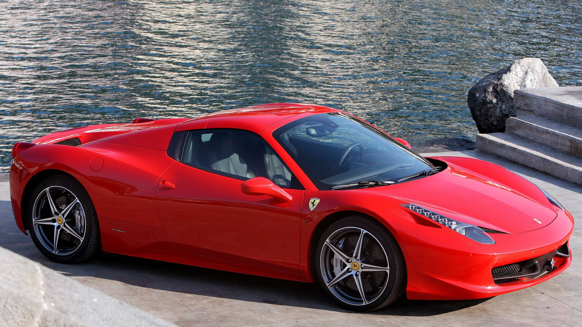 1920x1080 Ferrari 桌布 壁紙 — 一輛亮麗的紅色法拉利跑車停泊在漣漪水邊，附近有石階。