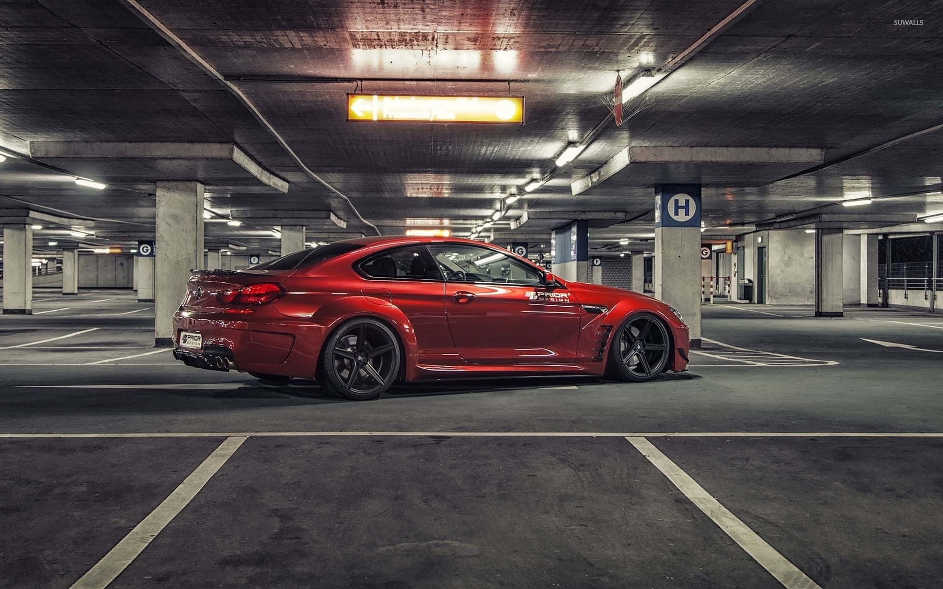 Bmw 6 Series 桌布 壁紙 — 一輛亮麗的紅色跑車停放在燈光昏暗的地下停車場，內有混凝土柱和天花板燈。