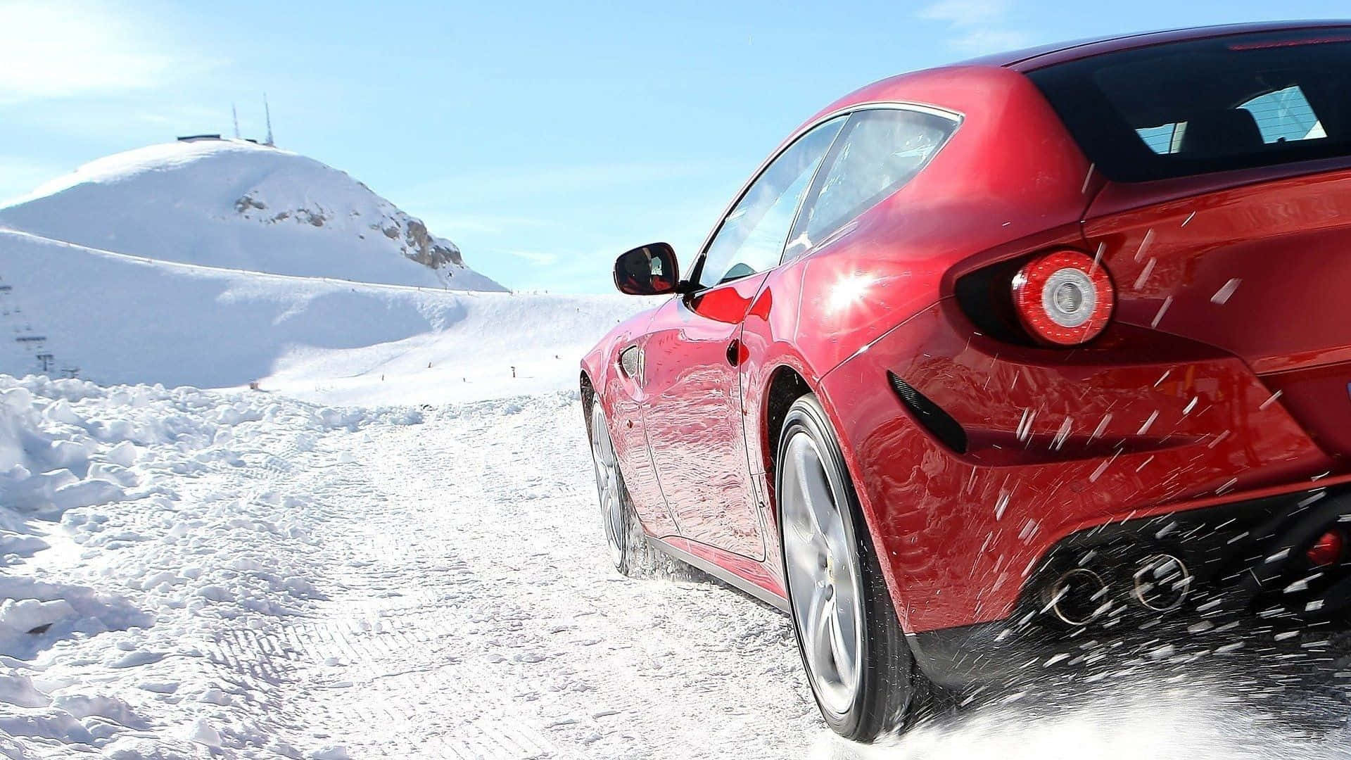 Ferrari Ff 桌布 壁紙 — 一輛亮麗的紅色跑車在晴朗藍天下，沿著積雪的山路疾馳，揚起雪花。