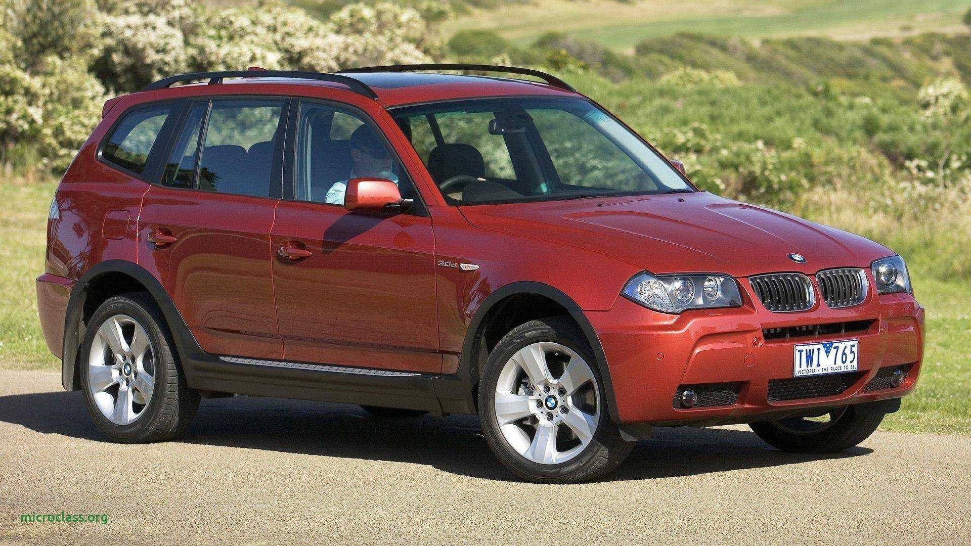 cars 桌布 壁紙 — 一輛亮麗紅色BMW X3 SUV停泊在碎石路上，背景是翠綠山丘和開花灌木叢，在明亮日光下。